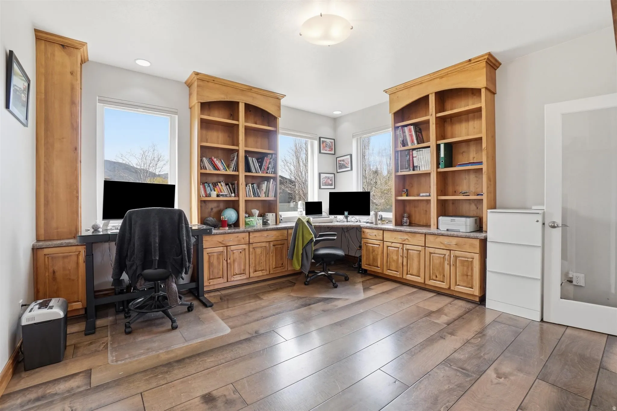 Home office with dark wood-style flooring and built in desk