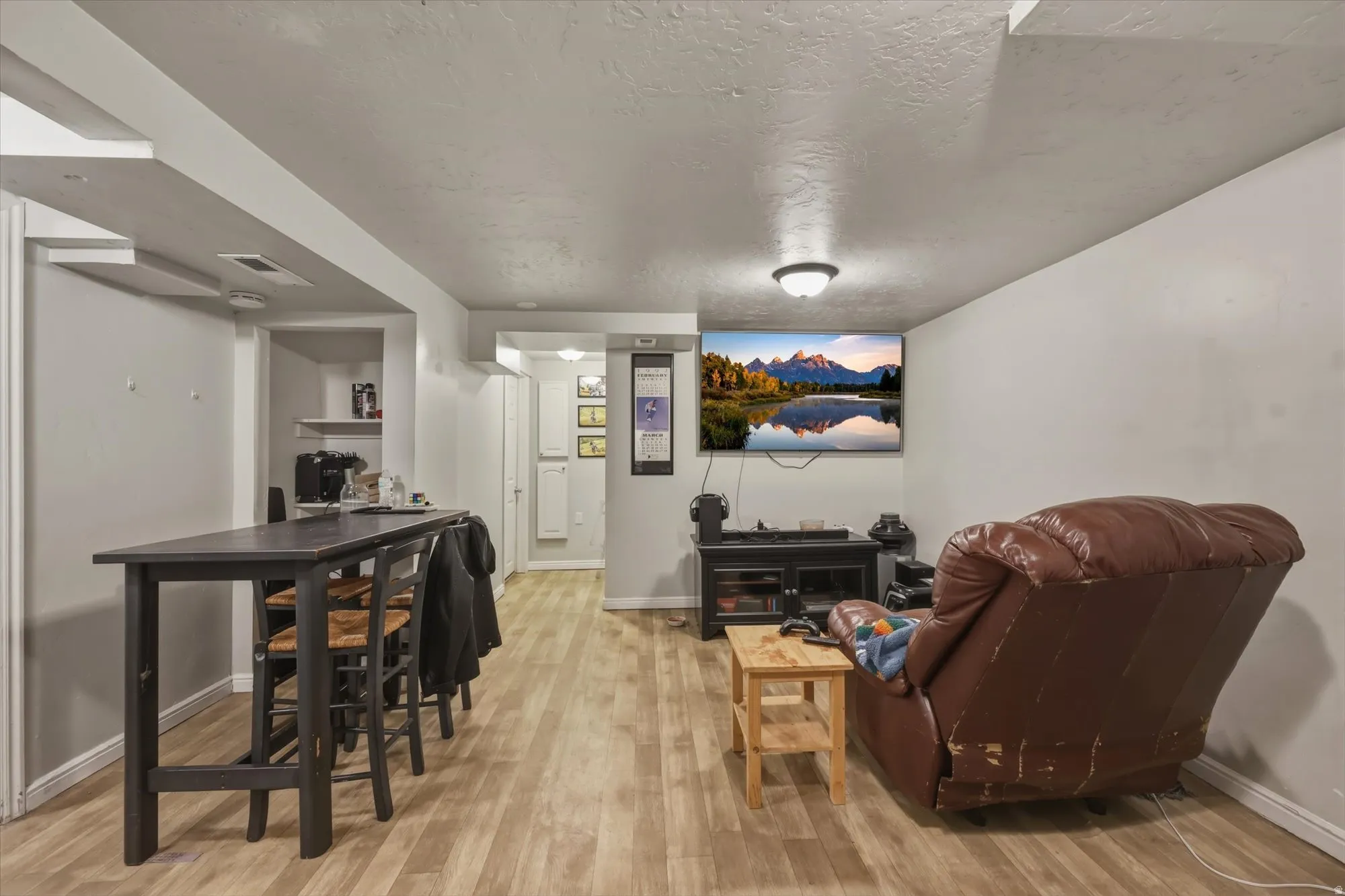 Living room with light wood finished floors and a textured ceiling