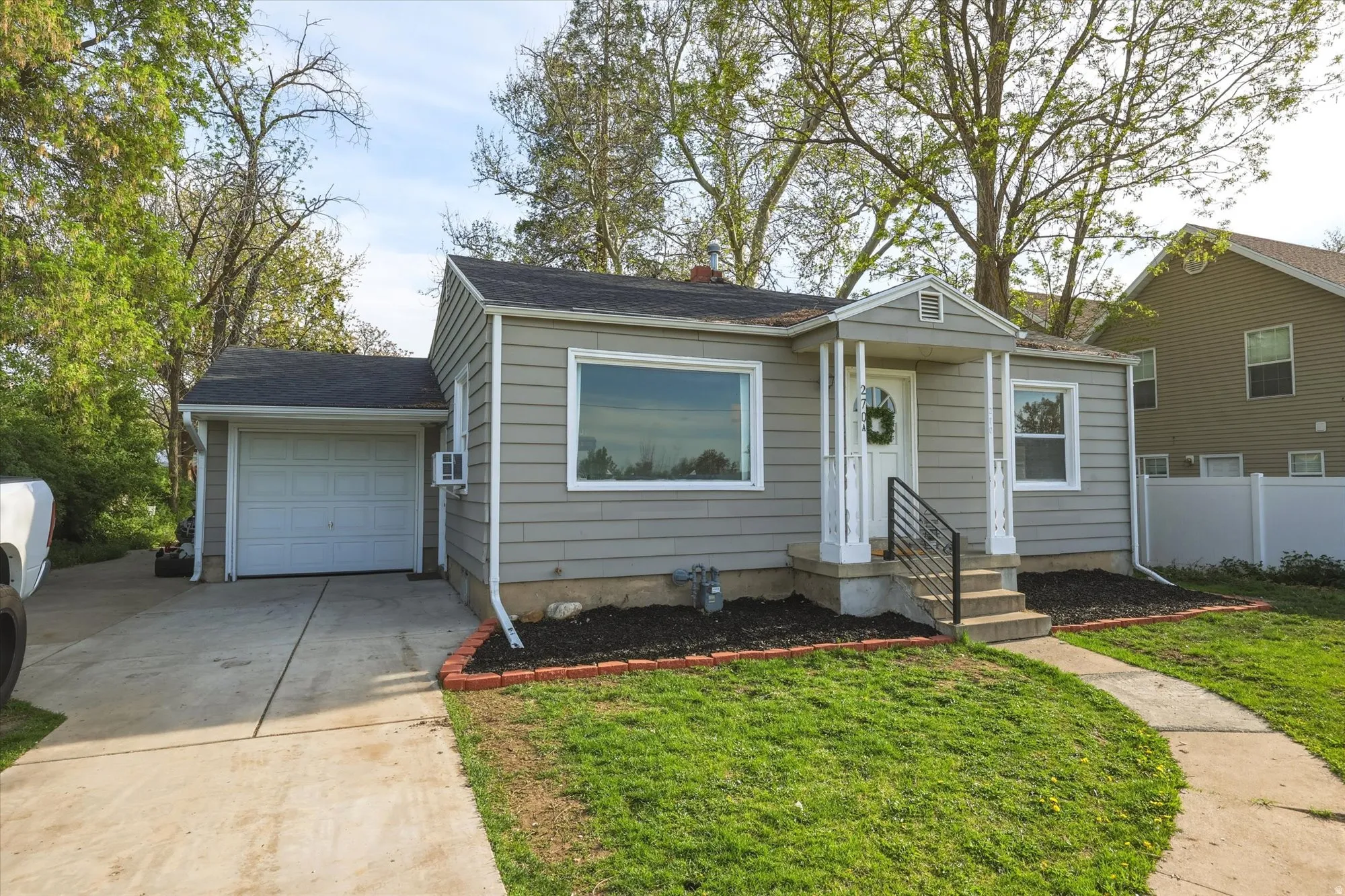 Bungalow-style house with a garage, driveway, and roof with shingles