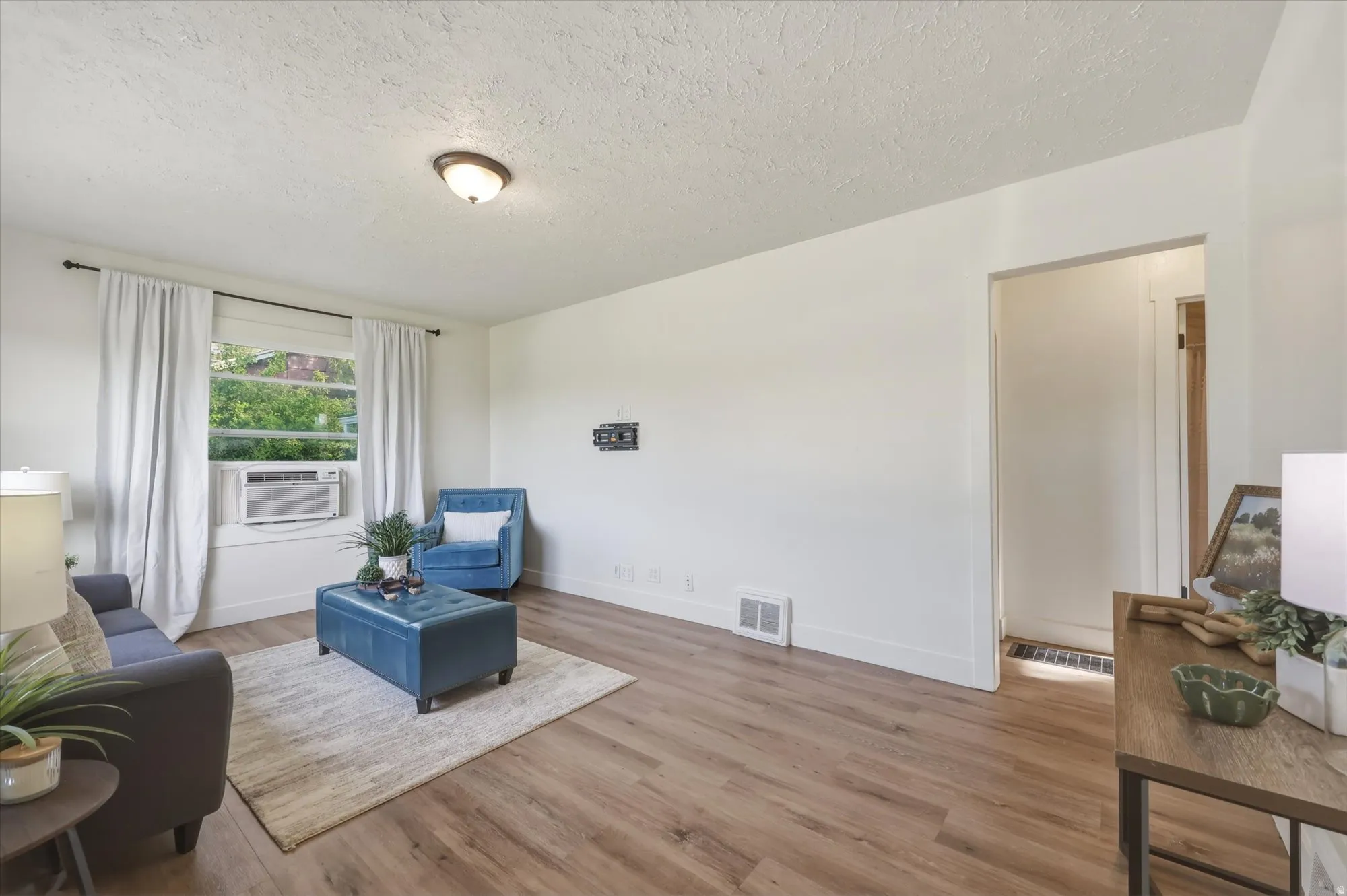 Living area featuring wood finished floors and a textured ceiling