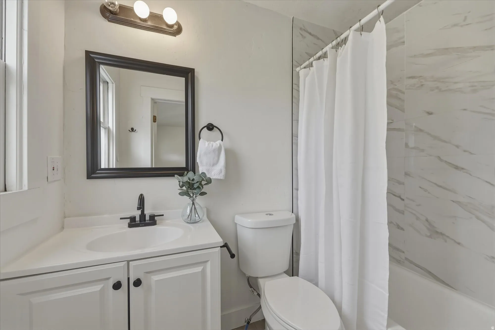Bathroom featuring vanity and shower / tub combo