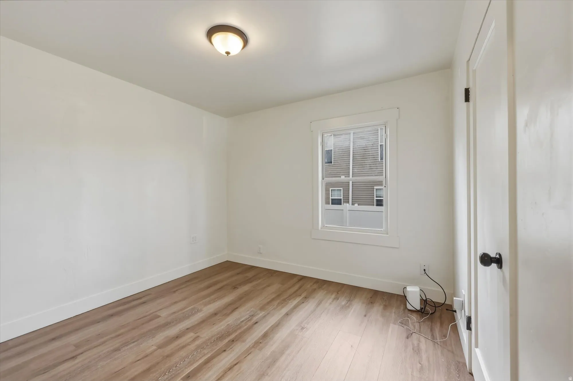 Unfurnished room with light wood-style floors and baseboards