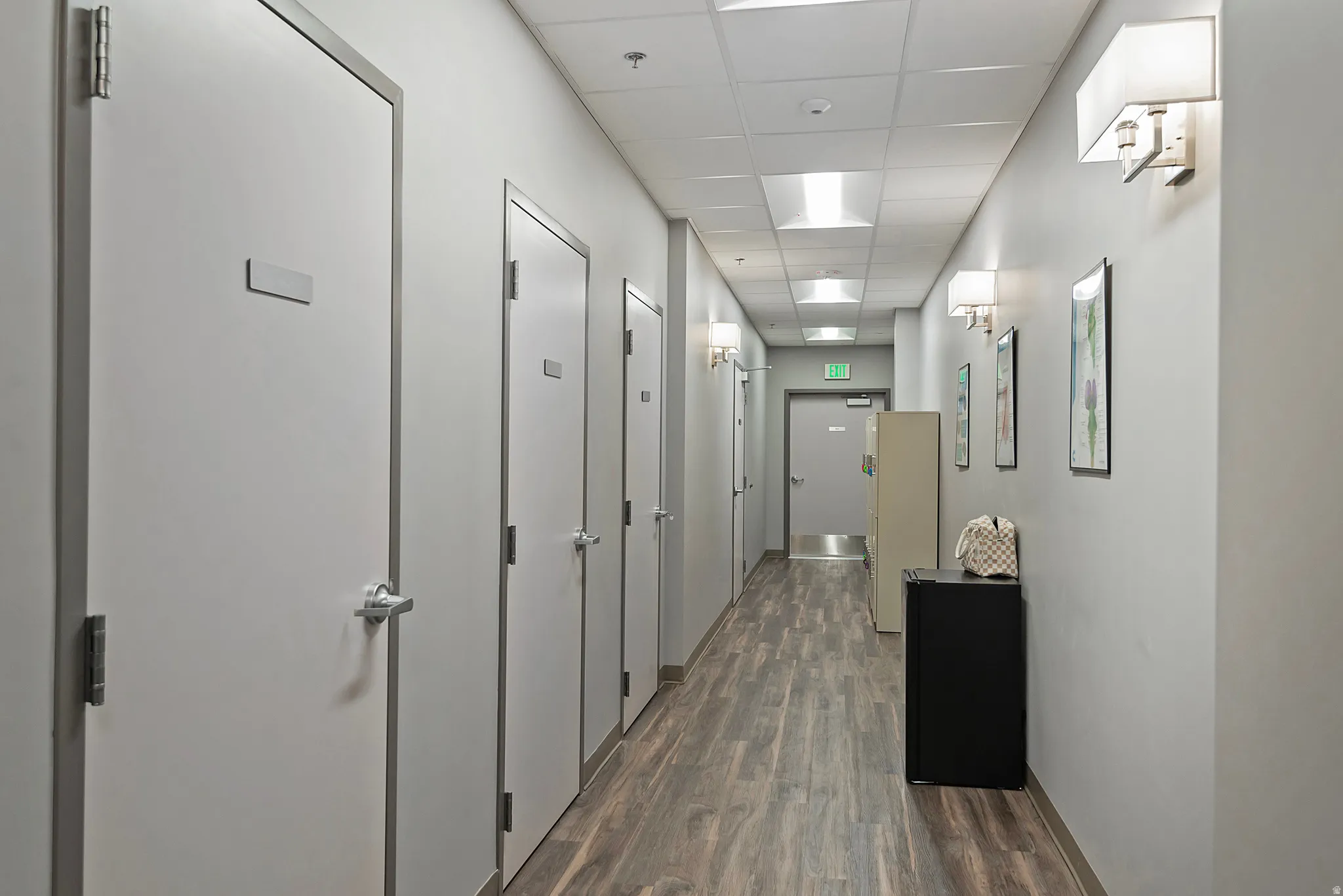 Hall featuring a drop ceiling and dark wood-style flooring