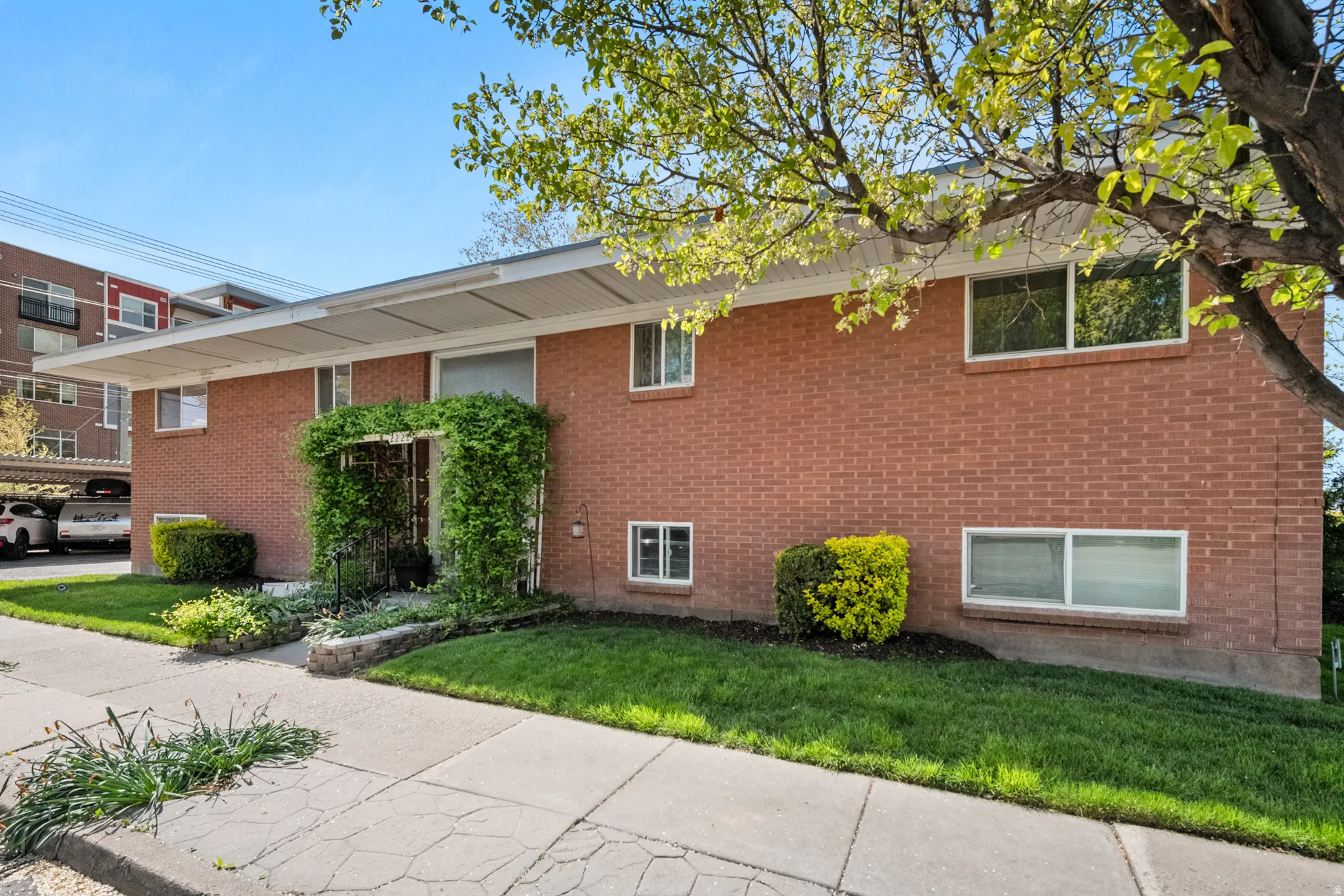 View of side of property with a lawn and brick siding