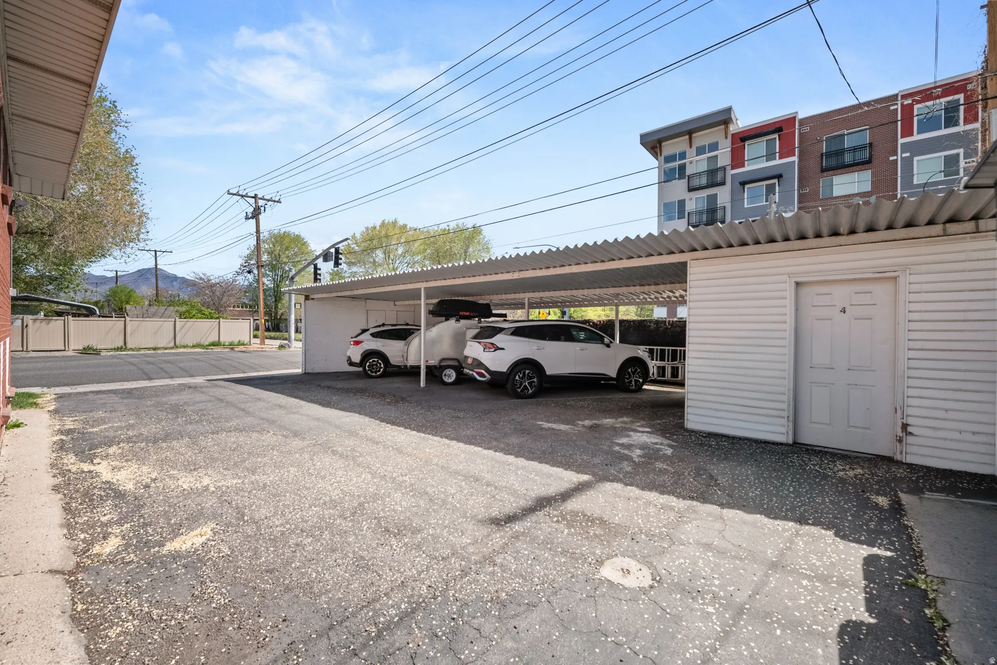 View of covered parking lot. Four stalls and exterior storage unit.