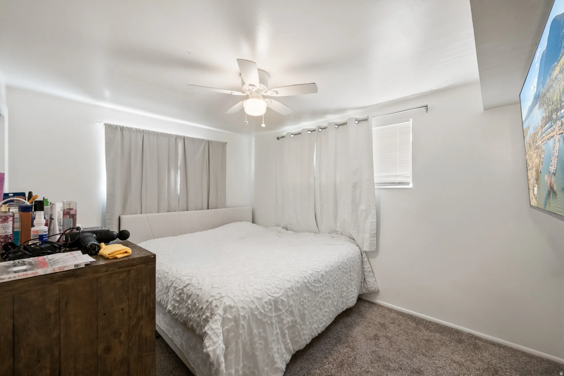 Carpeted bedroom with ceiling fan and baseboards