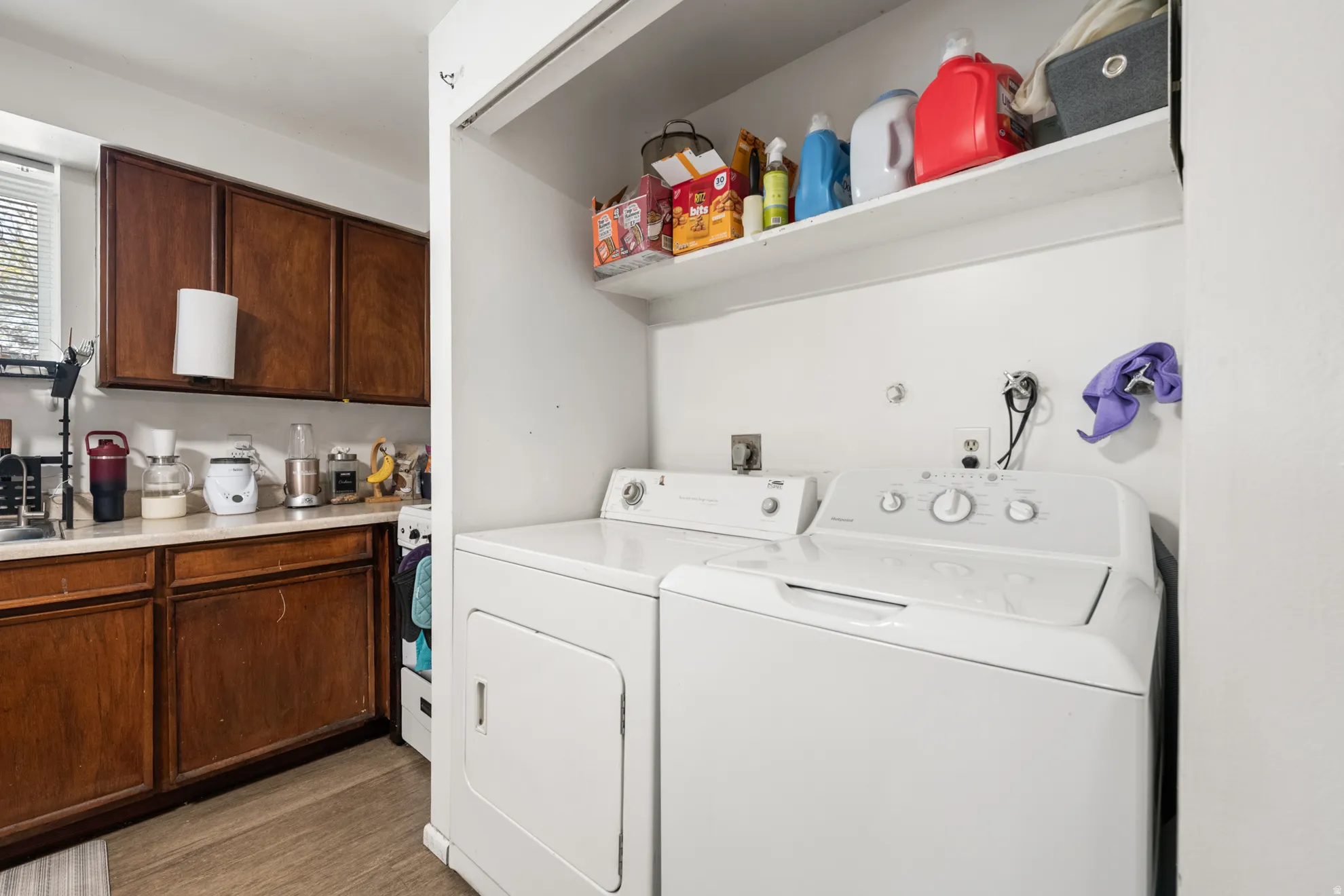 Laundry area with washer and dryer and light wood-style flooring