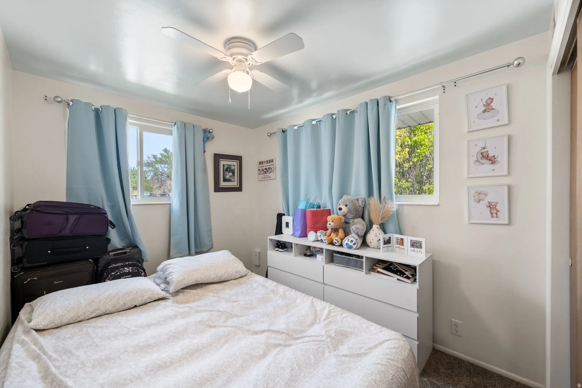Carpeted bedroom featuring a ceiling fan and baseboards