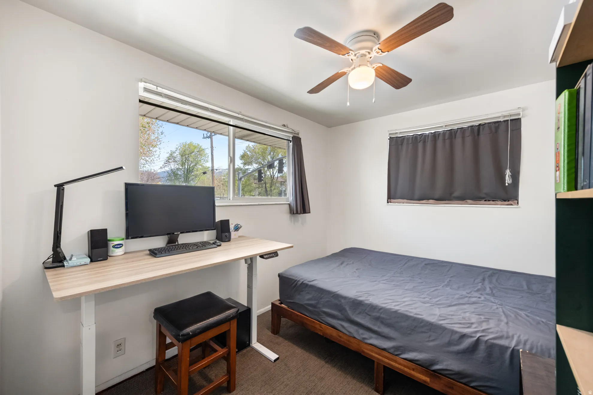 Bedroom featuring dark carpet, an office area, and ceiling fan