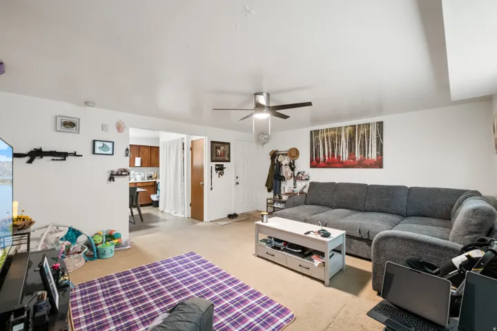 Living area with a ceiling fan and carpet