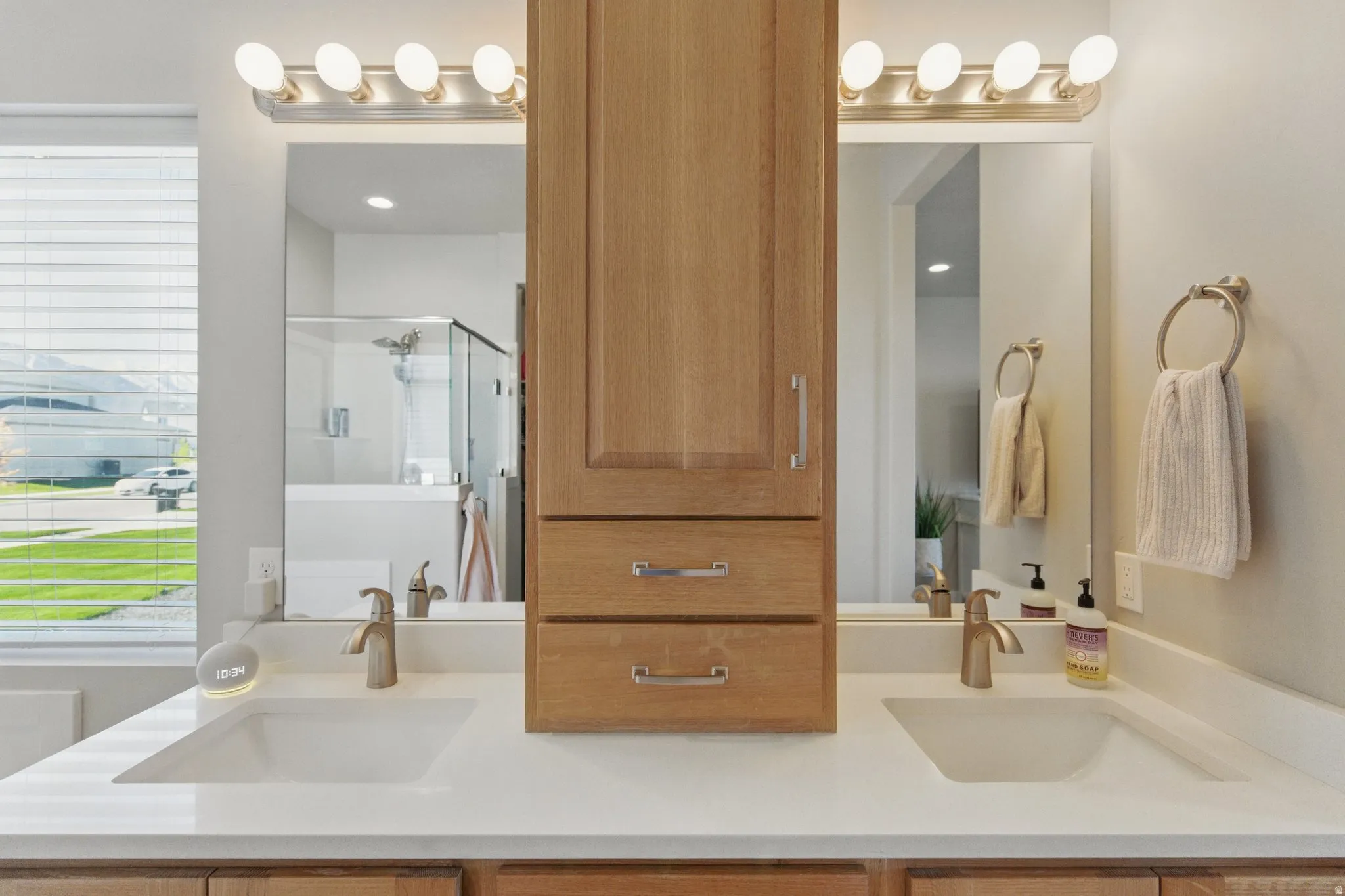 Full bathroom featuring double vanity and a shower stall