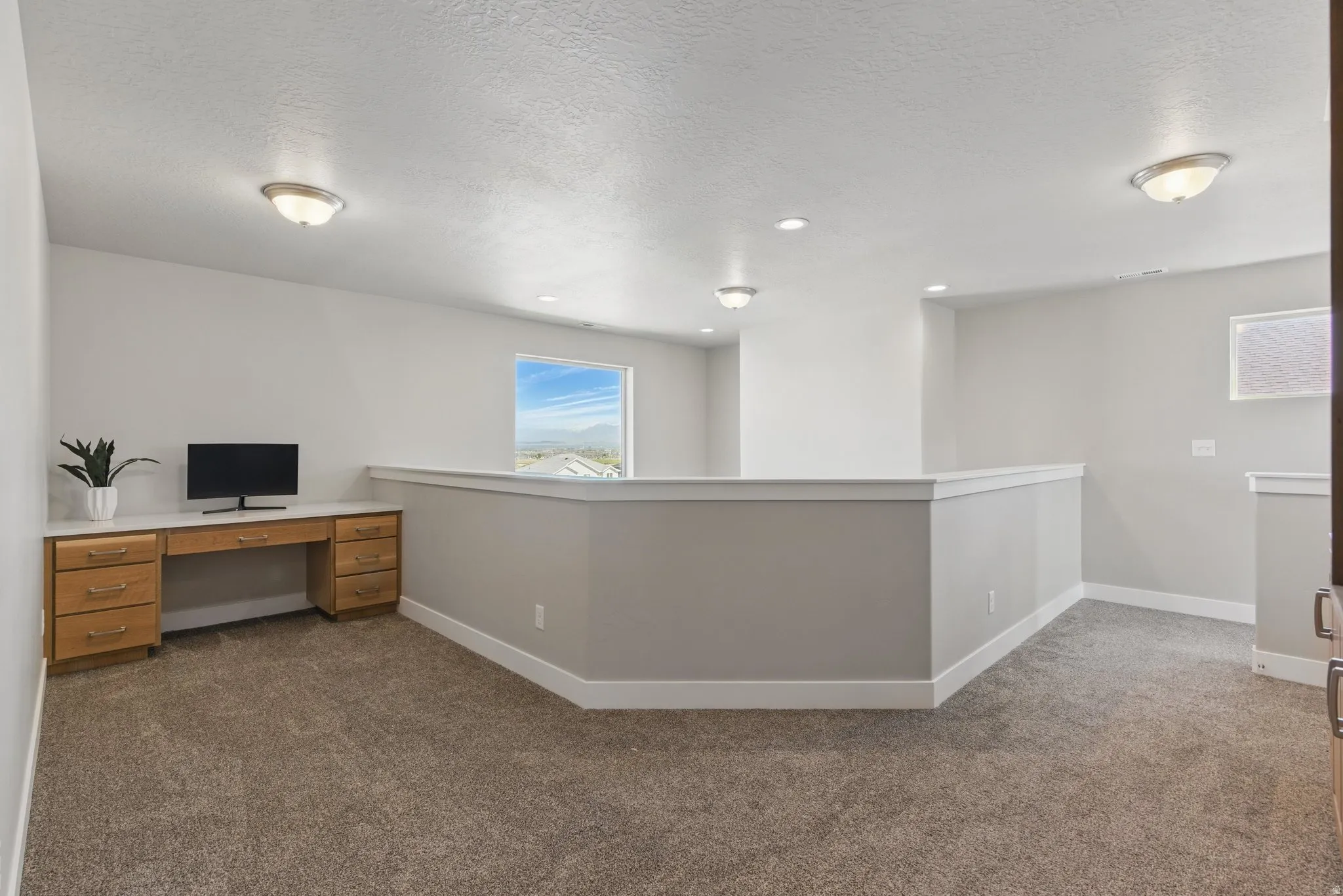 Unfurnished office featuring dark carpet and a textured ceiling