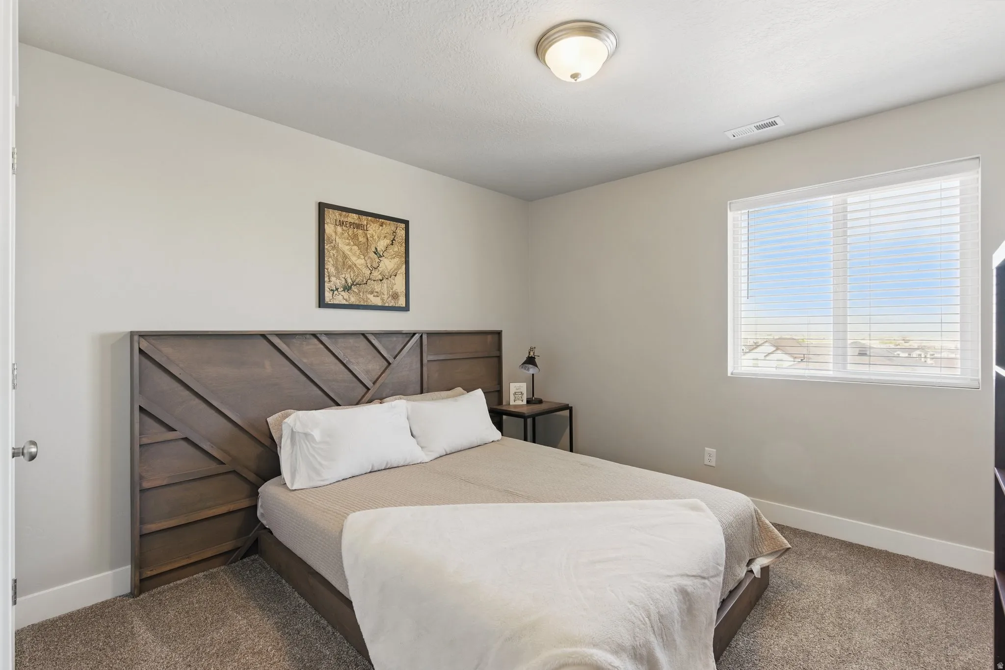 Bedroom with baseboards and dark colored carpet