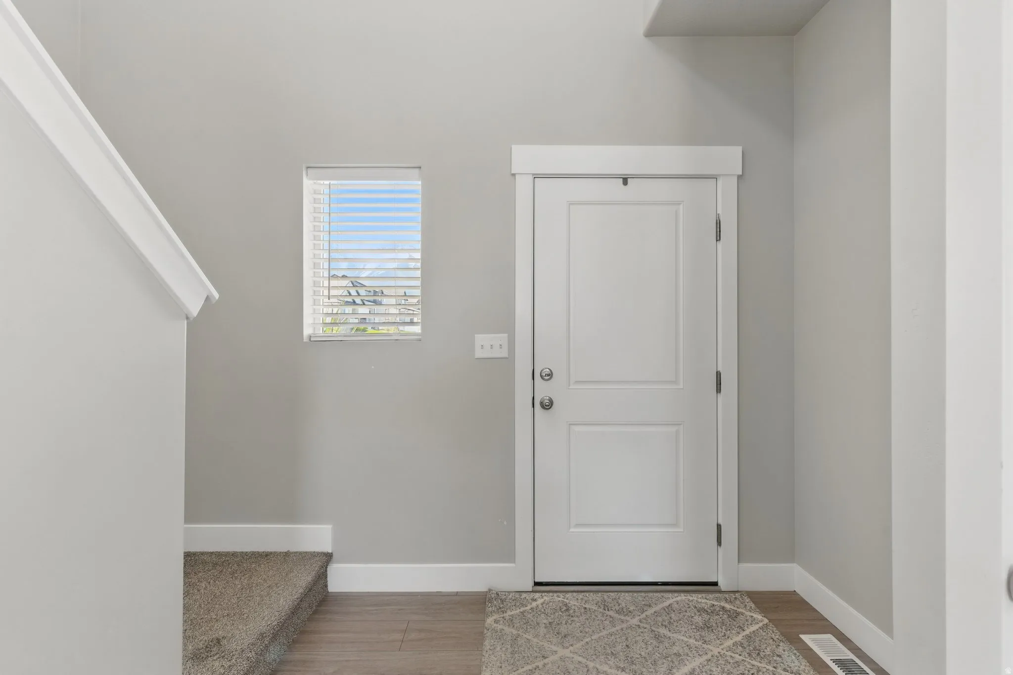 Foyer with baseboards and light wood-style flooring
