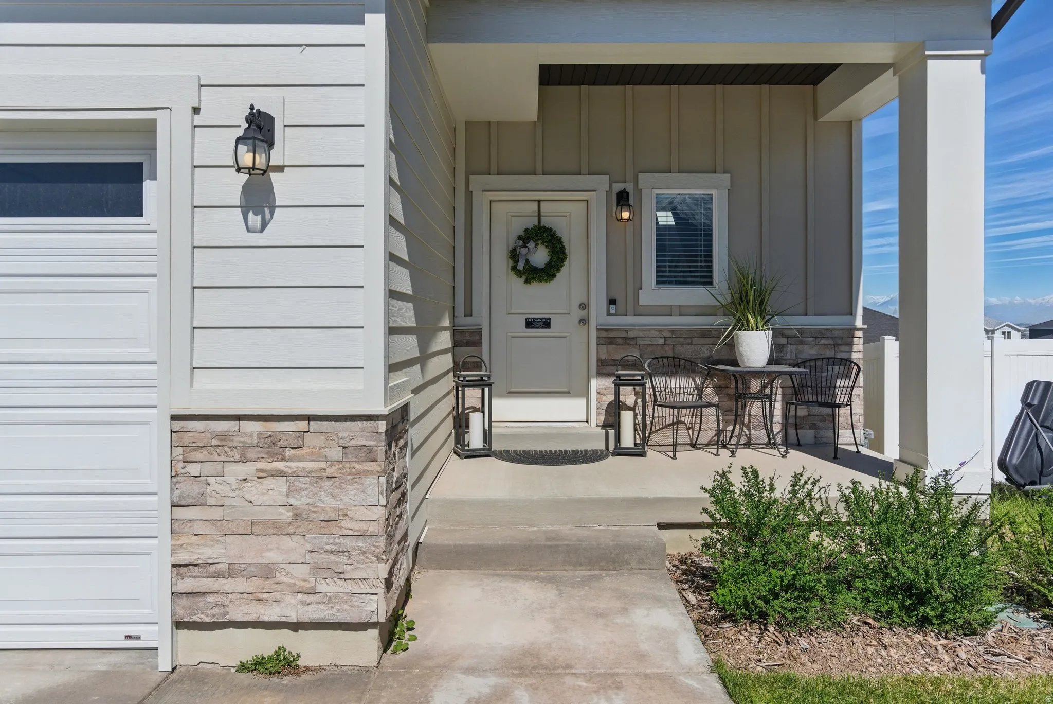 Property entrance featuring stone siding, board and batten siding, and covered porch