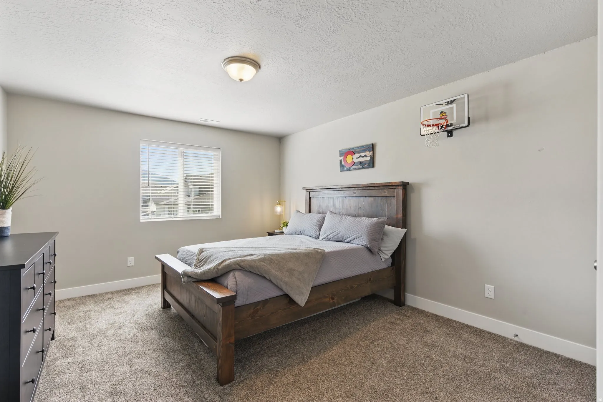 Carpeted bedroom with baseboards and a textured ceiling