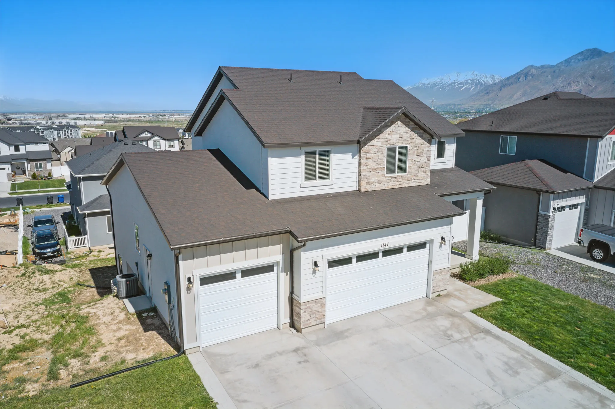 View of front of property with stone siding, a shingled roof, a residential view, and board and batten siding