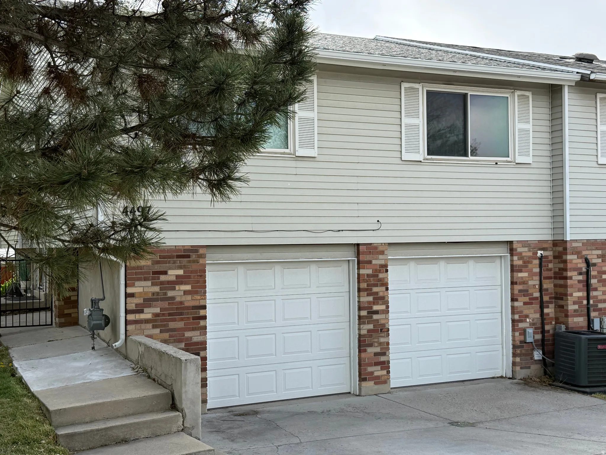 View of side of property featuring brick siding, driveway, and a garage