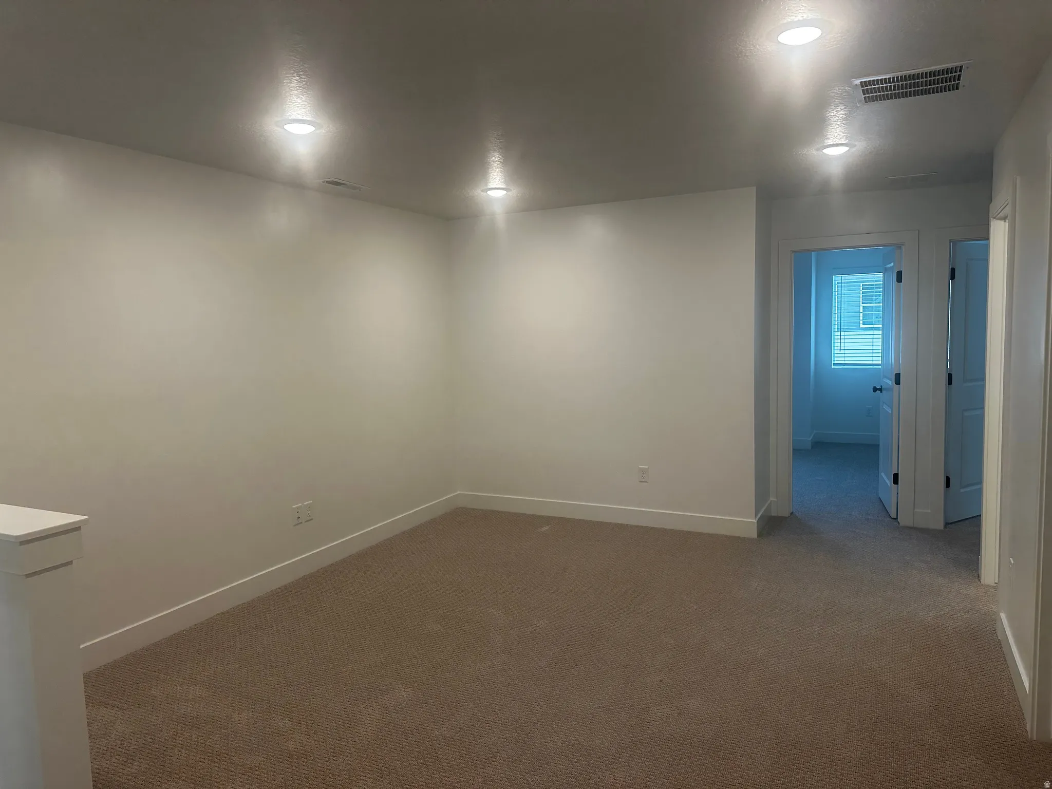 Spare room featuring baseboards and dark carpet
