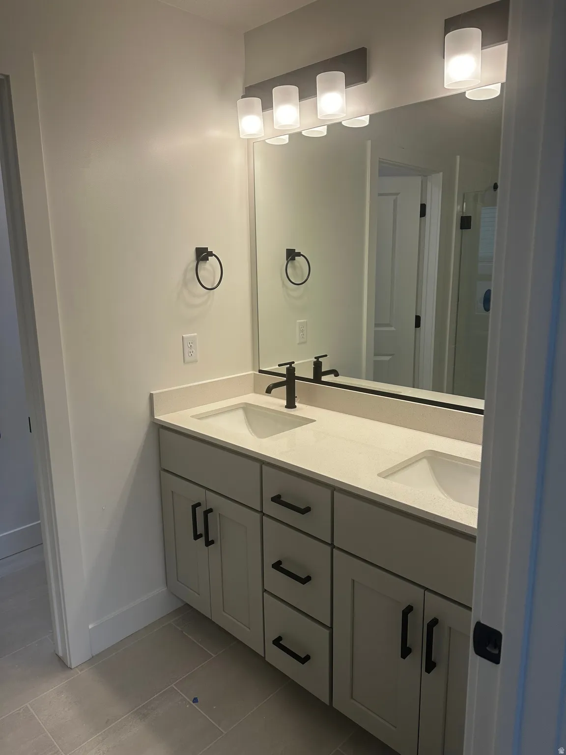 Full bathroom featuring double vanity and light tile patterned floors