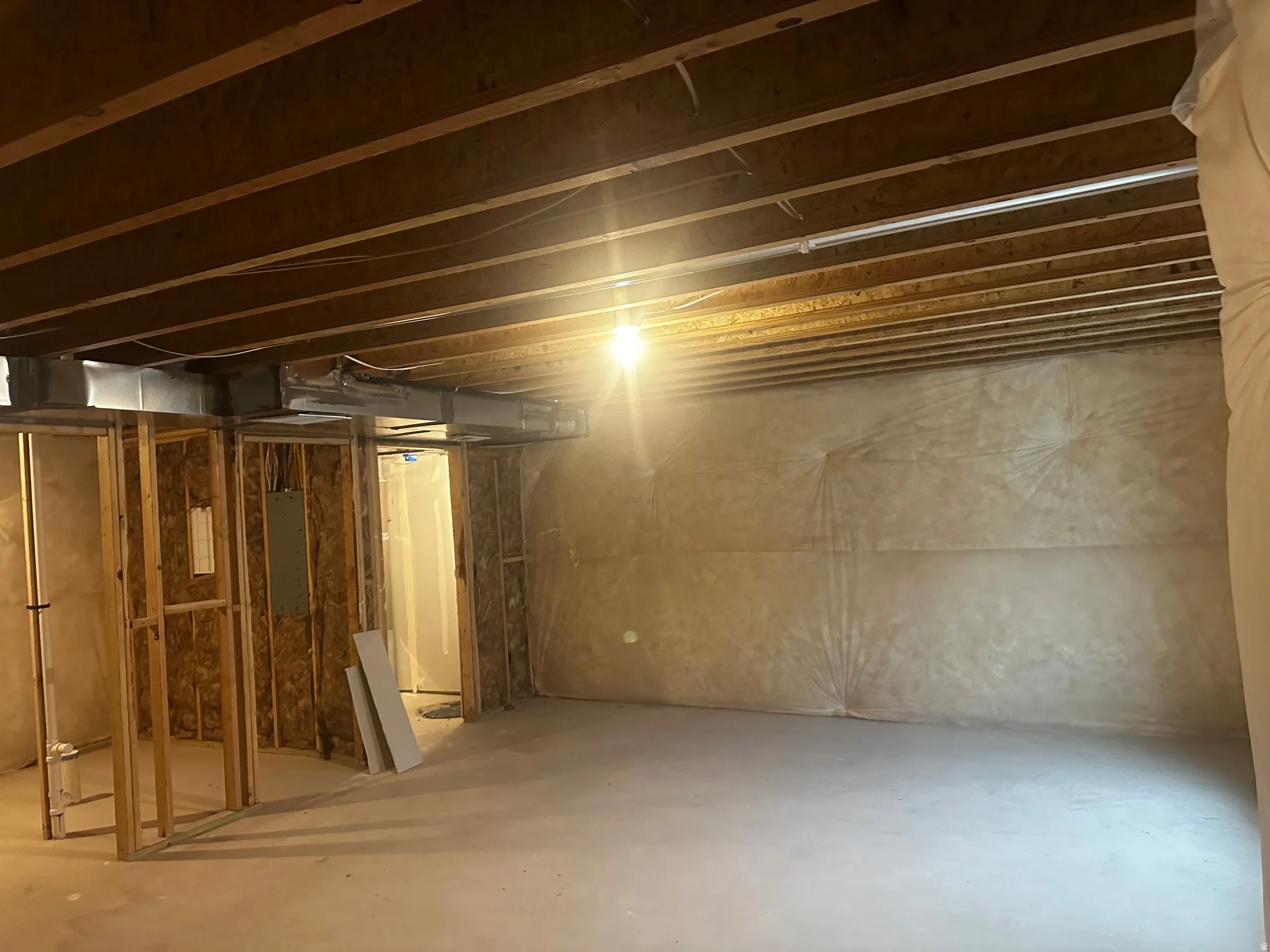 Unfinished basement with electric panel