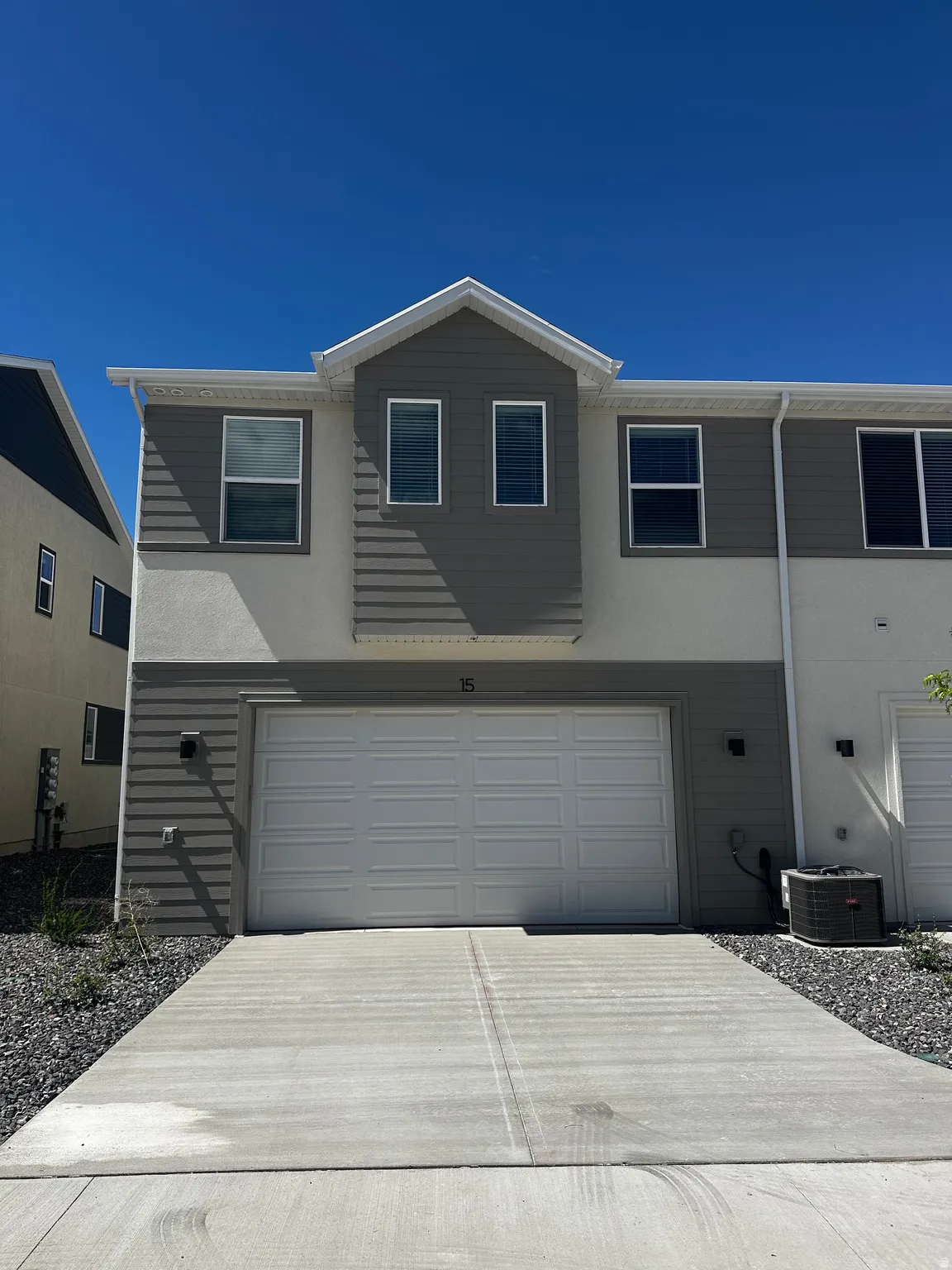 Traditional-style house with a garage, concrete driveway, and stucco siding