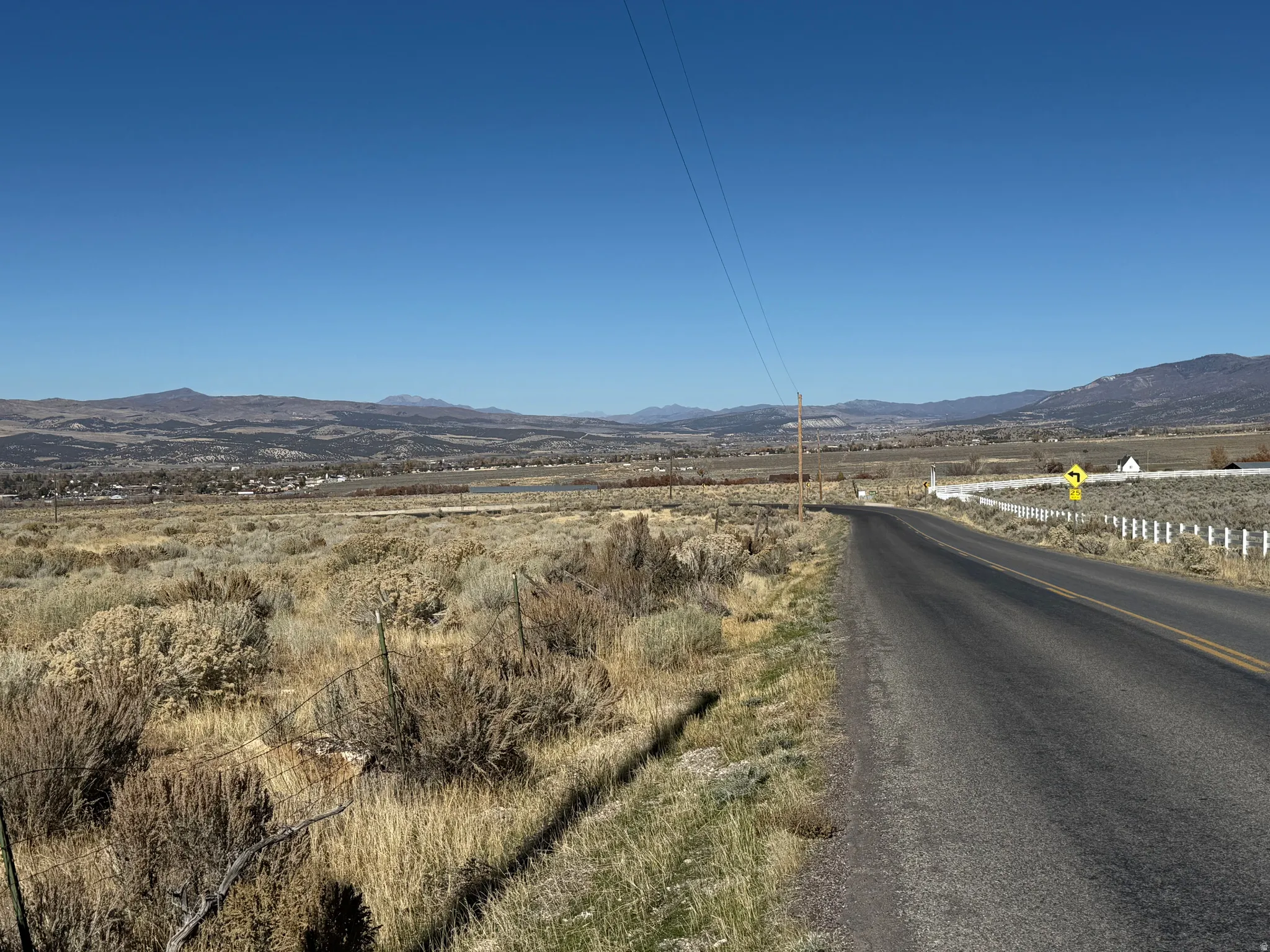 View of asphalt road featuring a mountain view and a view of countryside