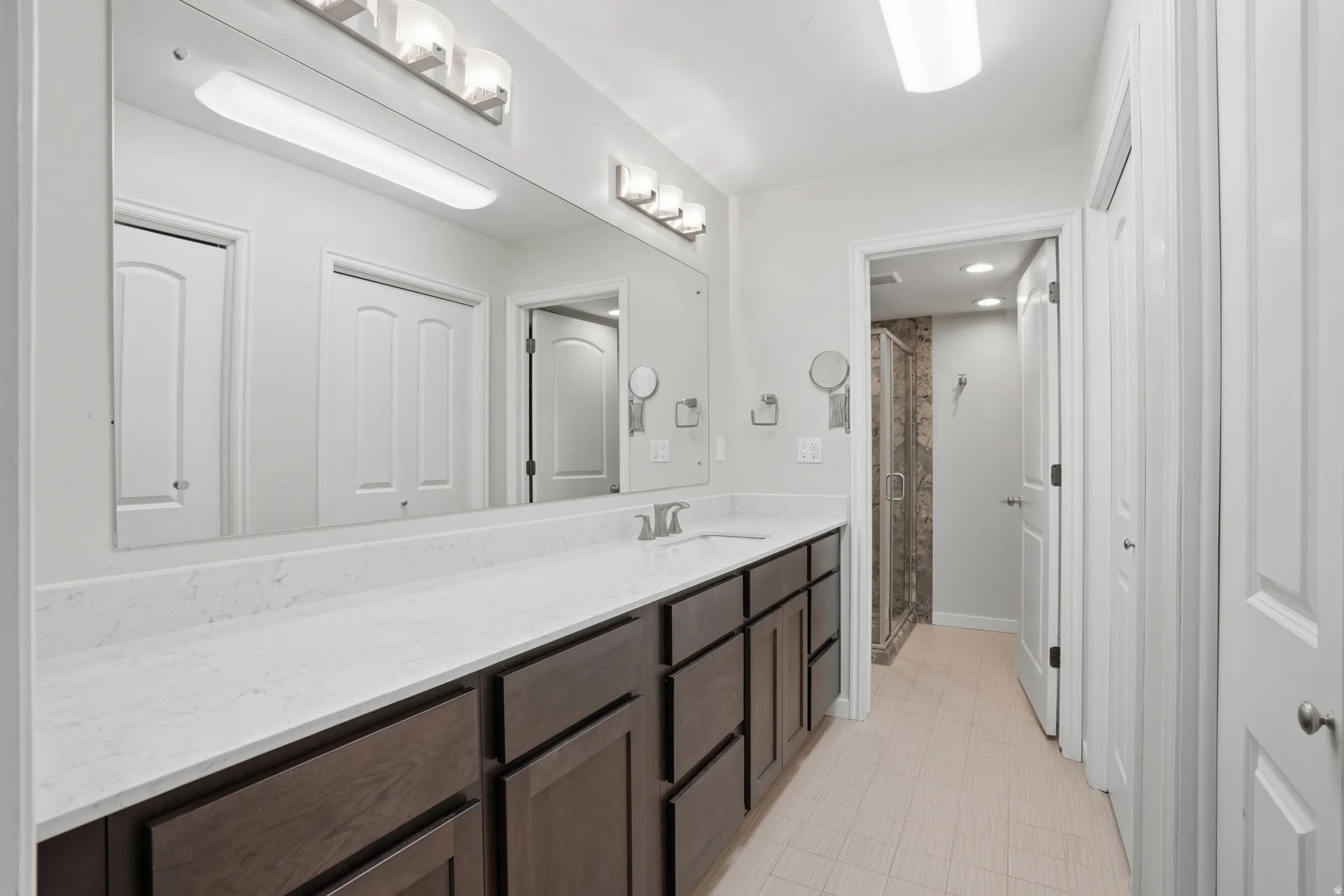 Bathroom featuring a stall shower and vanity, lots of closet space