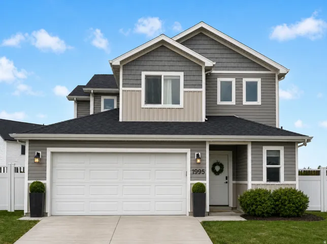 Traditional-style house with board and batten siding, concrete driveway, a garage, and a shingled roof