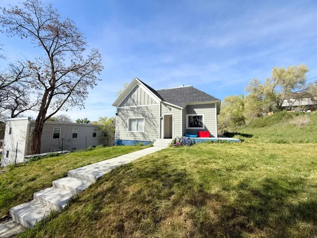 View of front of house featuring board and batten siding, a front yard, and a shingled roof