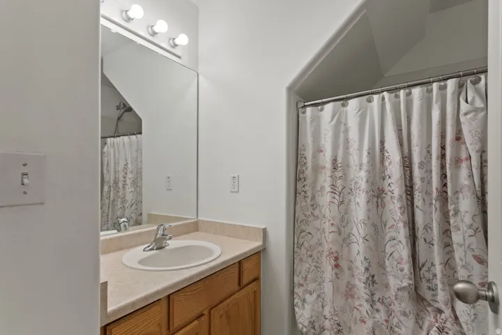 Bathroom with a shower with curtain and vanity