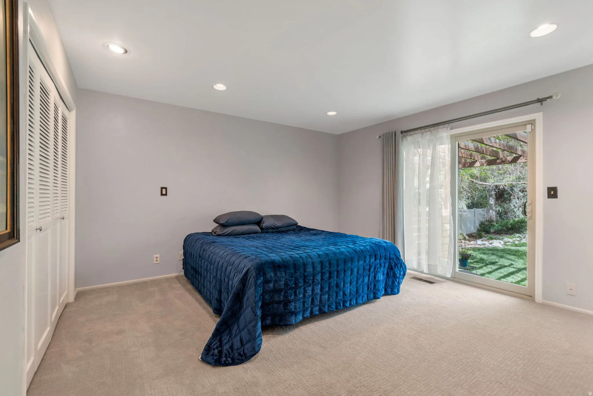 Bedroom featuring light colored carpet, recessed lighting, and access to outside