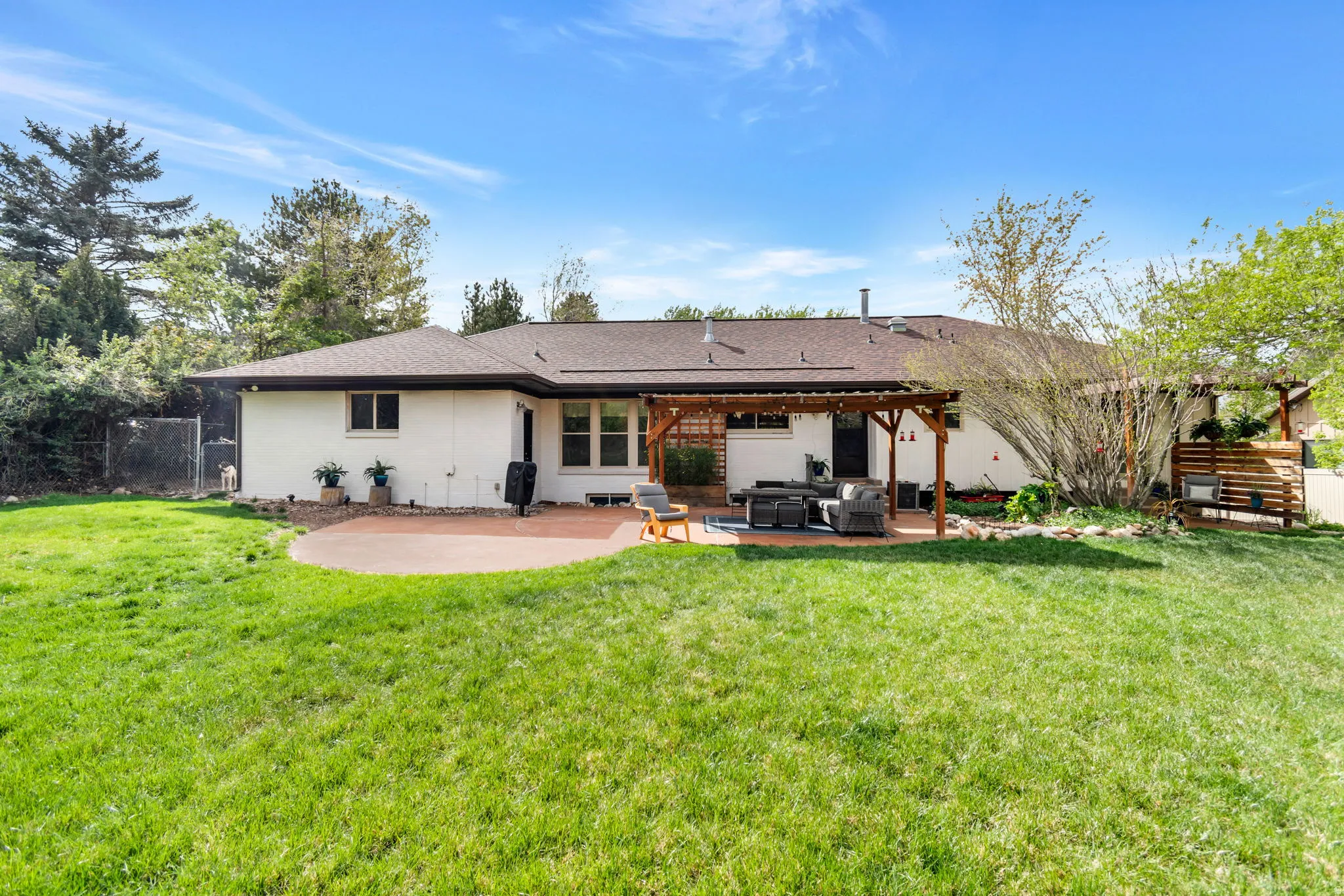 Back of property featuring a patio, roof with shingles, a fenced backyard, and outdoor furniture
