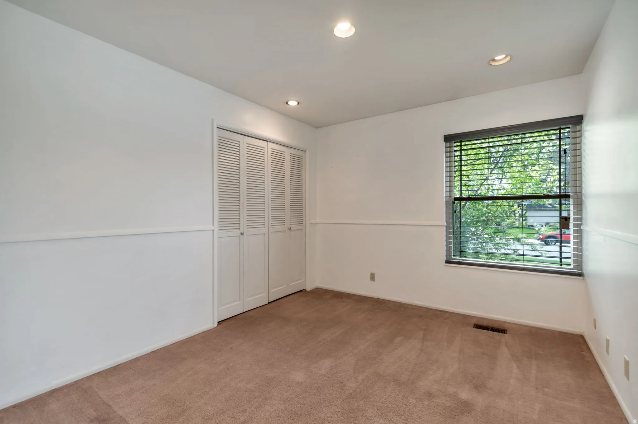 Unfurnished bedroom featuring recessed lighting, carpet floors, and a closet