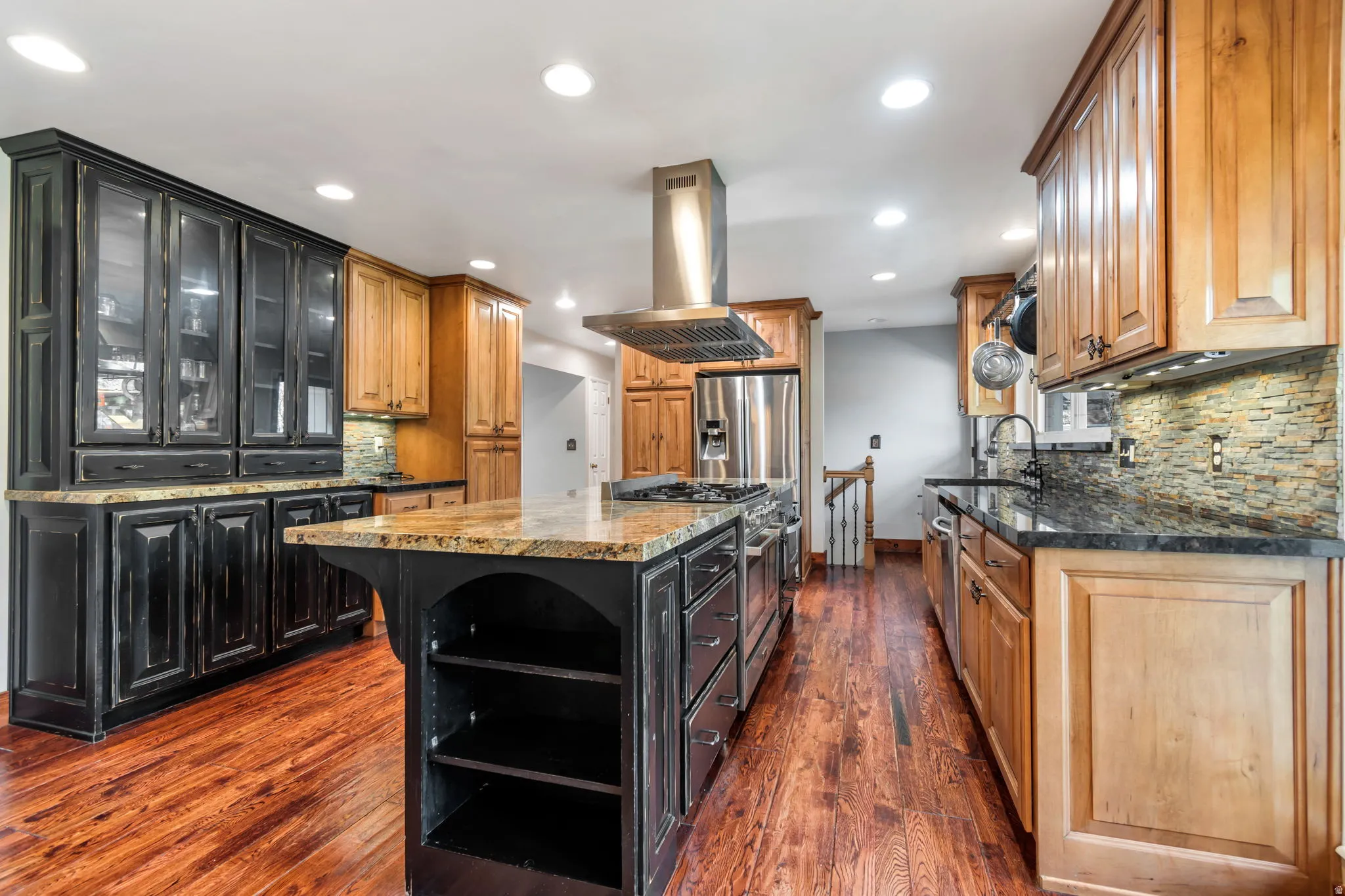 Kitchen with backsplash, island range hood, dark stone countertops, dark wood-style flooring, and recessed lighting