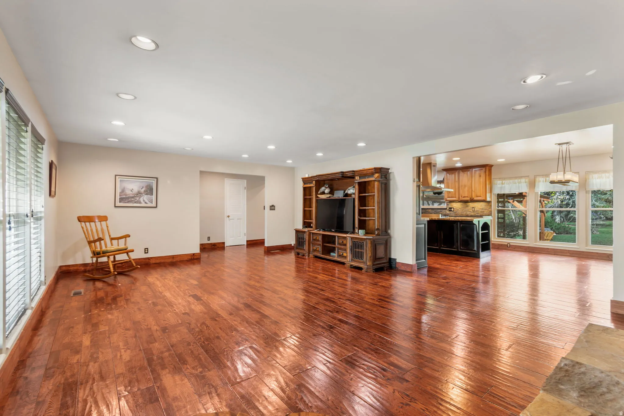 Living area with plenty of natural light, dark wood-style floors, and recessed lighting