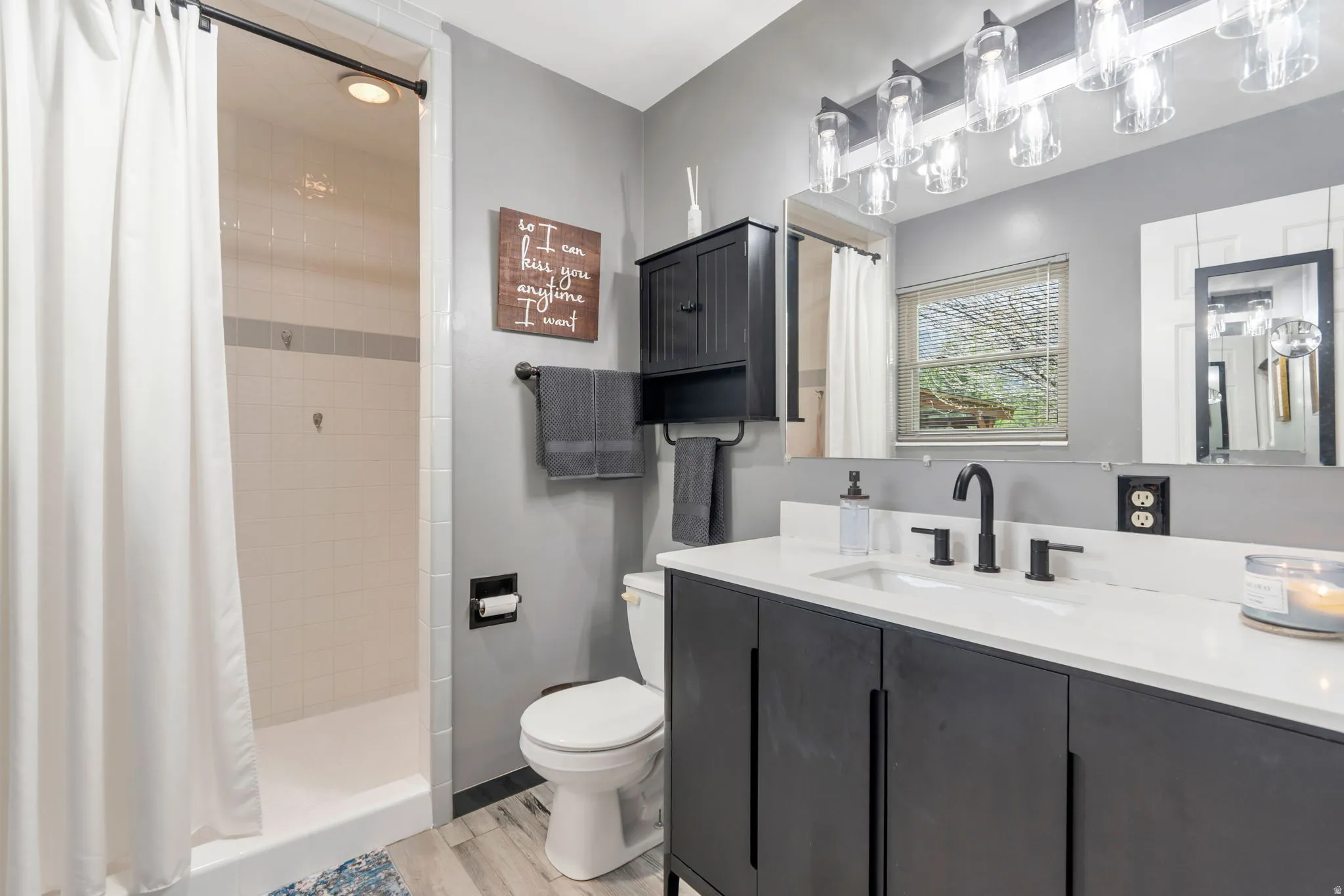 Bathroom with a stall shower, vanity, and light wood-style flooring