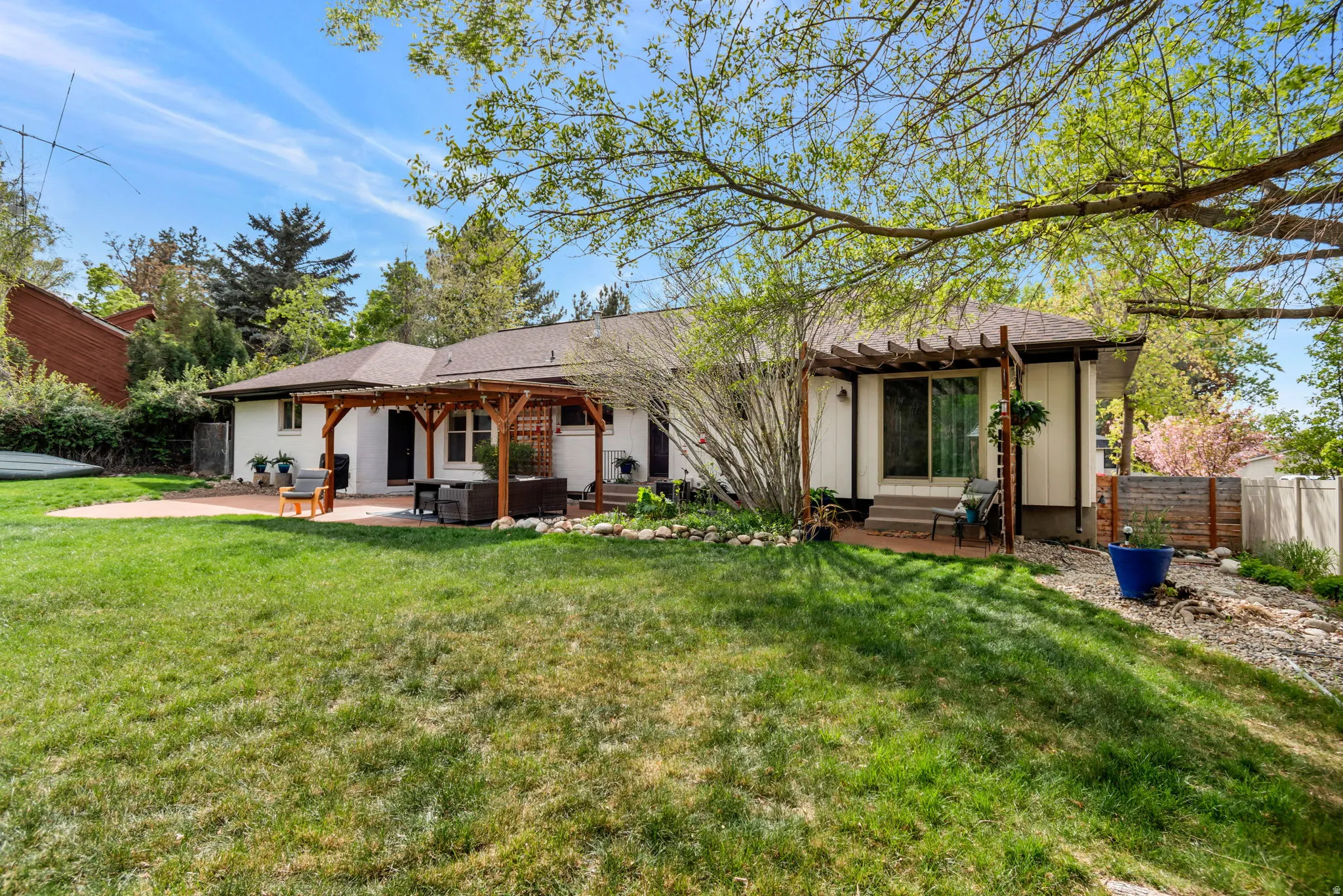 Back of property featuring a patio, roof with shingles, and a pergola