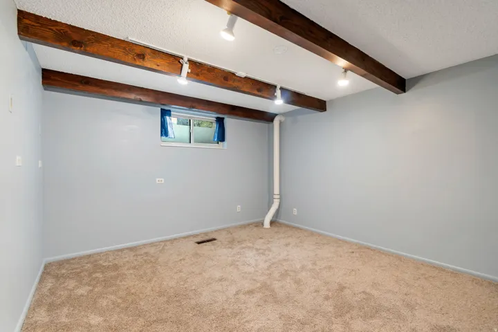 Basement featuring a textured ceiling and carpet