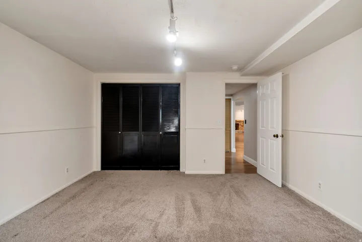 Unfurnished bedroom with light colored carpet and a closet