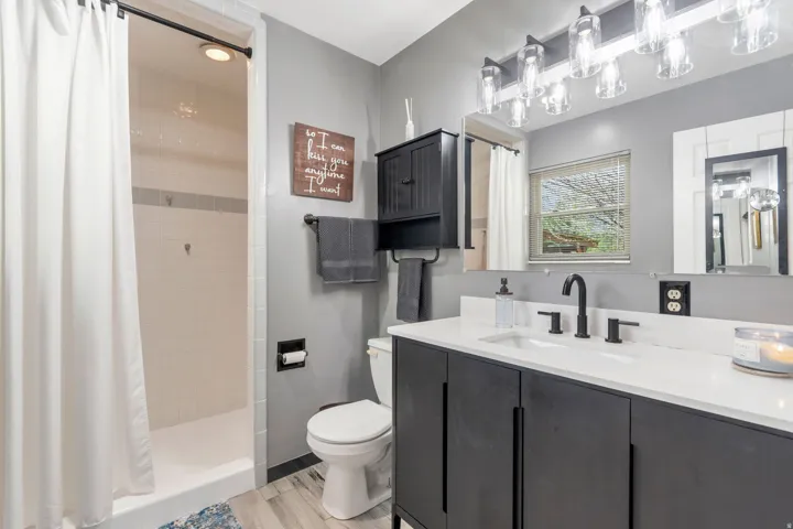 Bathroom with a stall shower, vanity, and light wood-style flooring