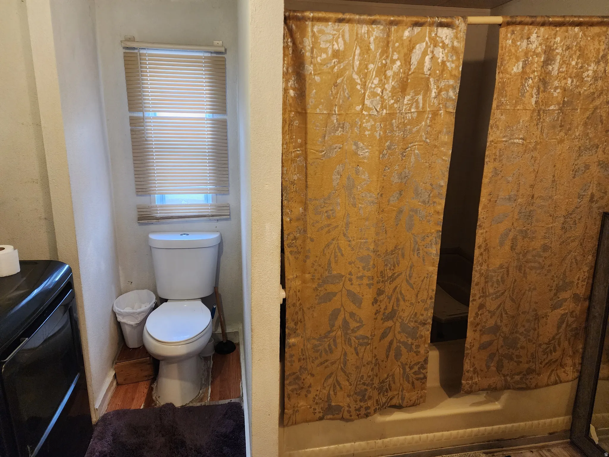 Bathroom featuring wood finished floors and curtained shower