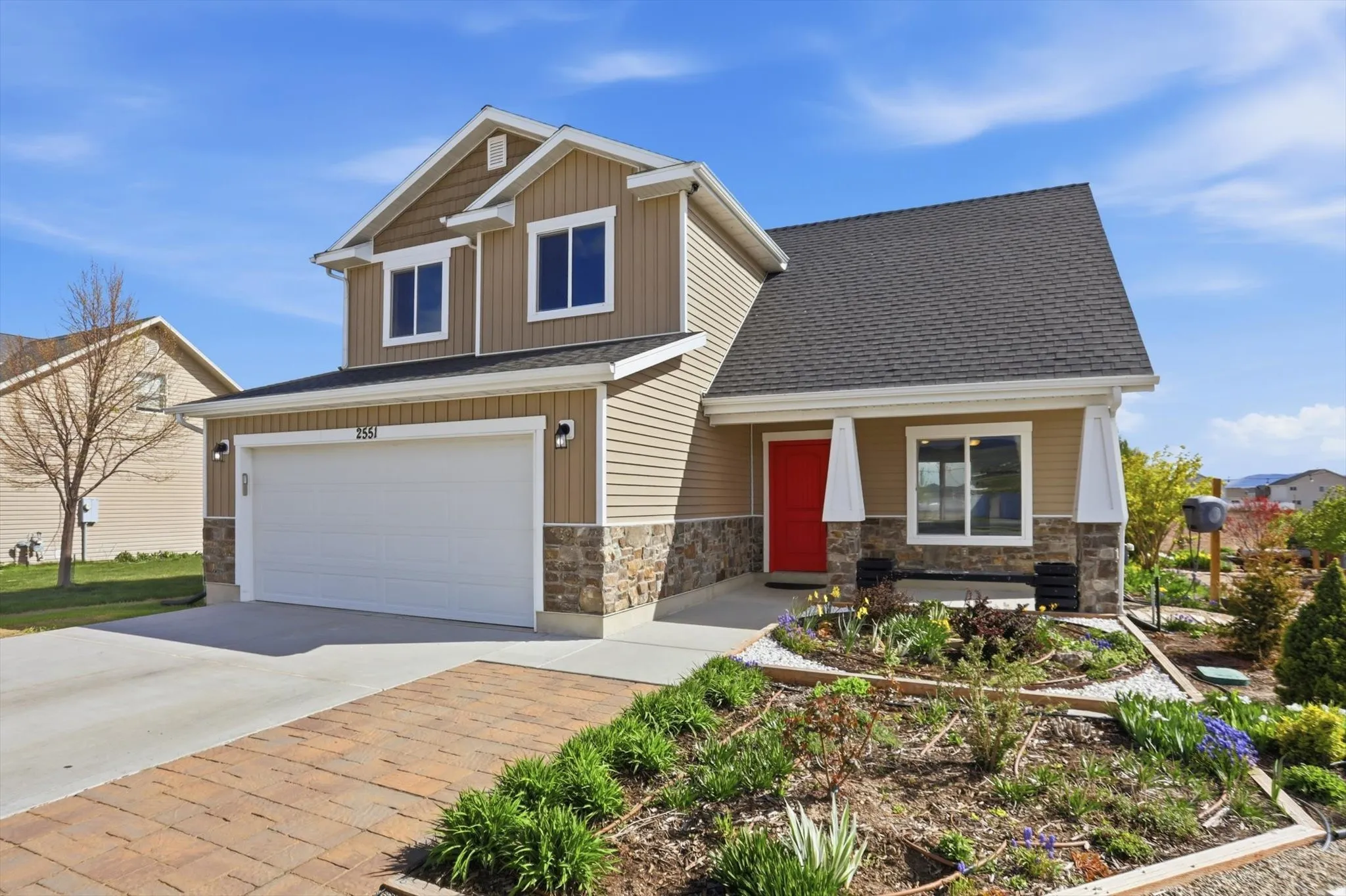 Craftsman house featuring a garage, concrete driveway, board and batten siding, covered porch, and stone siding