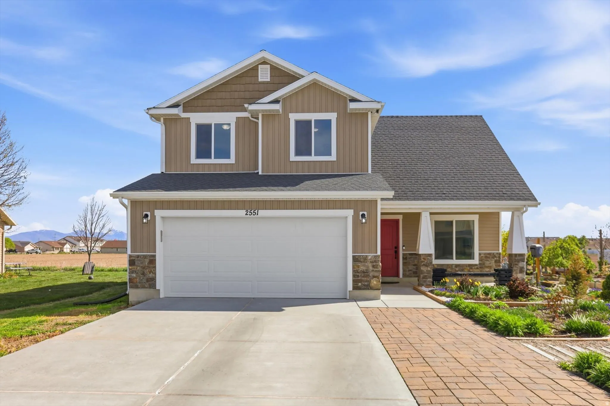 Craftsman inspired home with stone siding, a garage, driveway, roof with shingles, and a porch