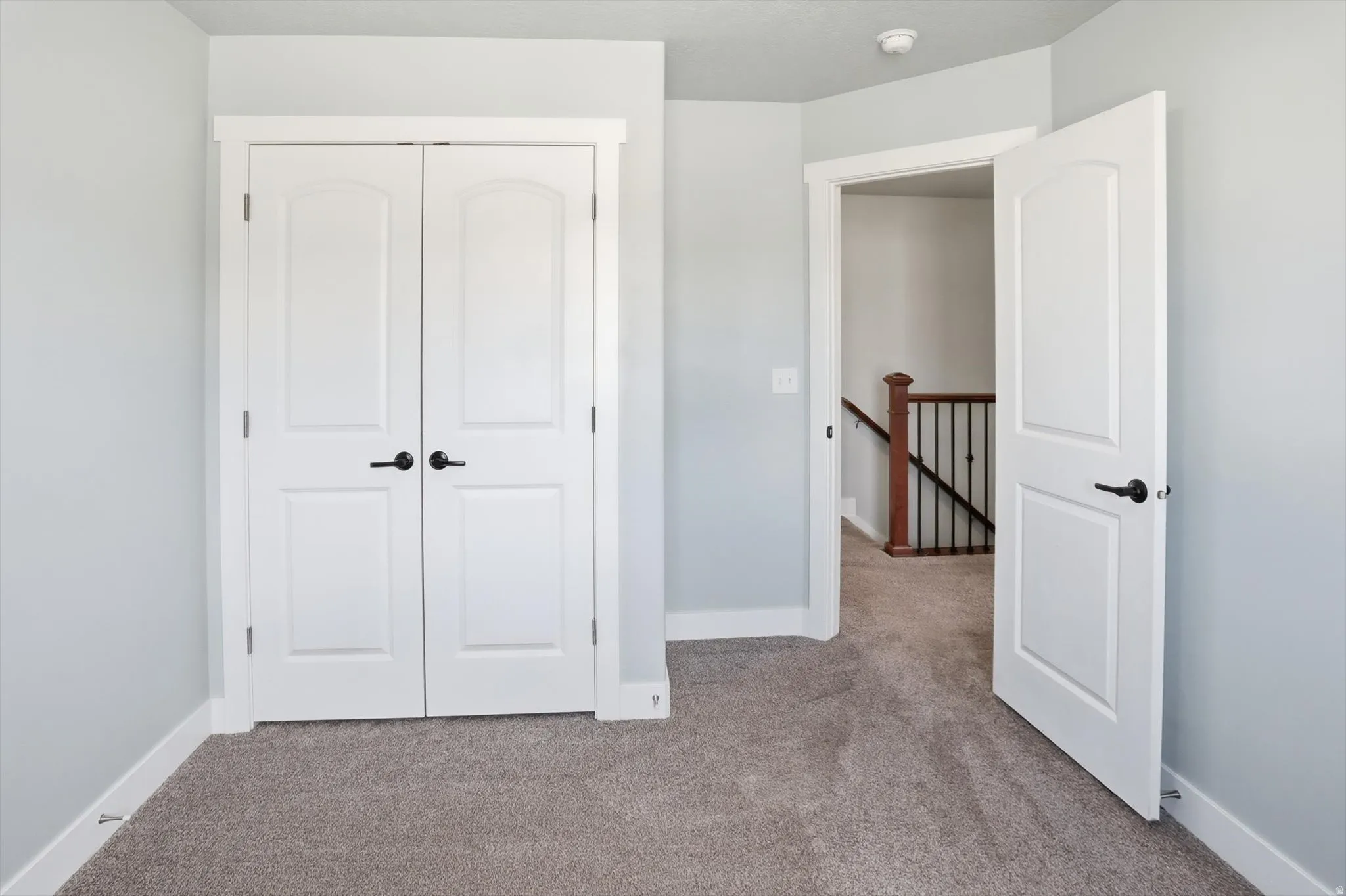 Unfurnished bedroom with light carpet and a closet