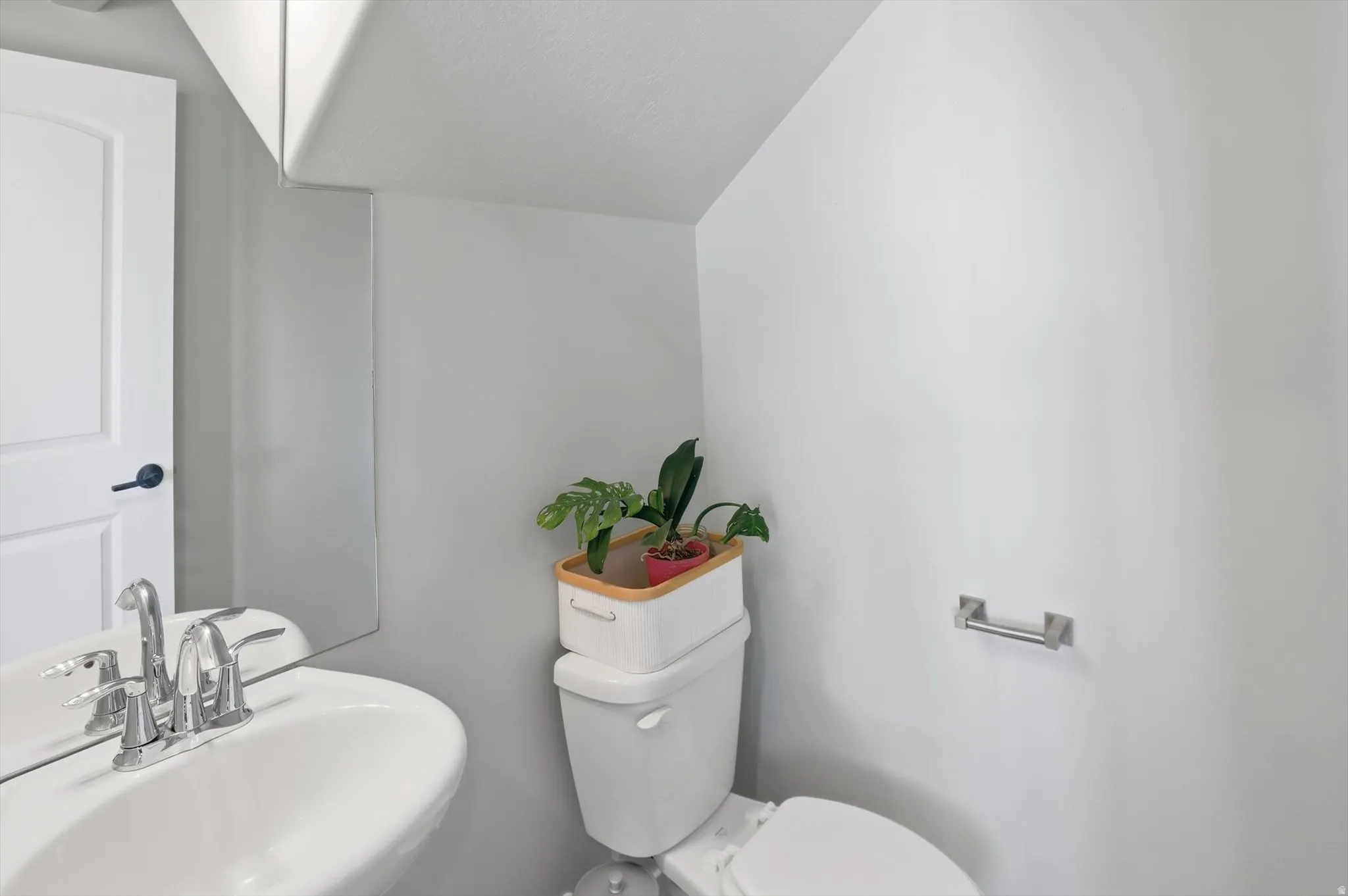 Bathroom featuring a sink and lofted ceiling