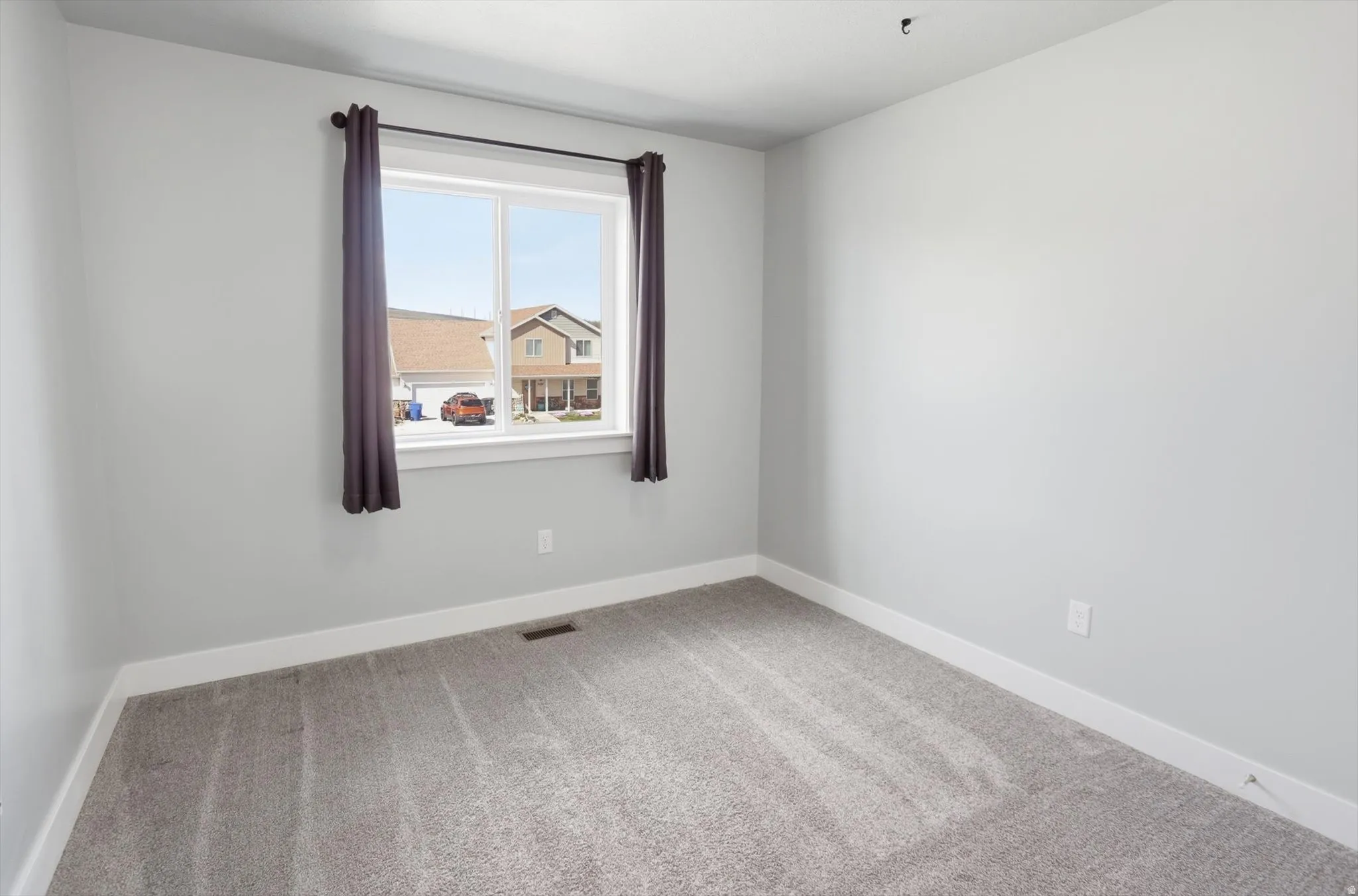 Empty room with baseboards and light carpet