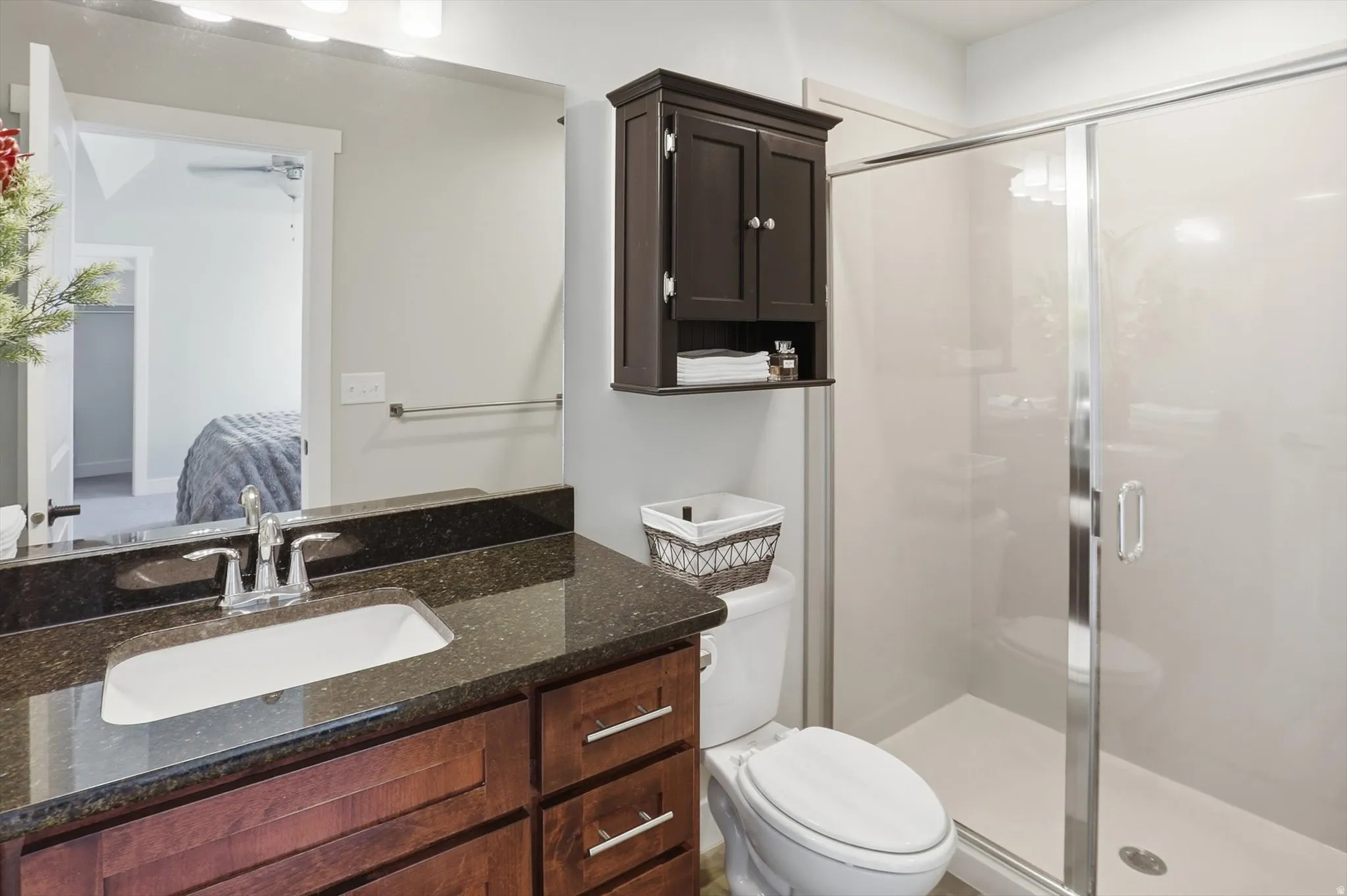 Ensuite bathroom with a stall shower, vanity, and ceiling fan