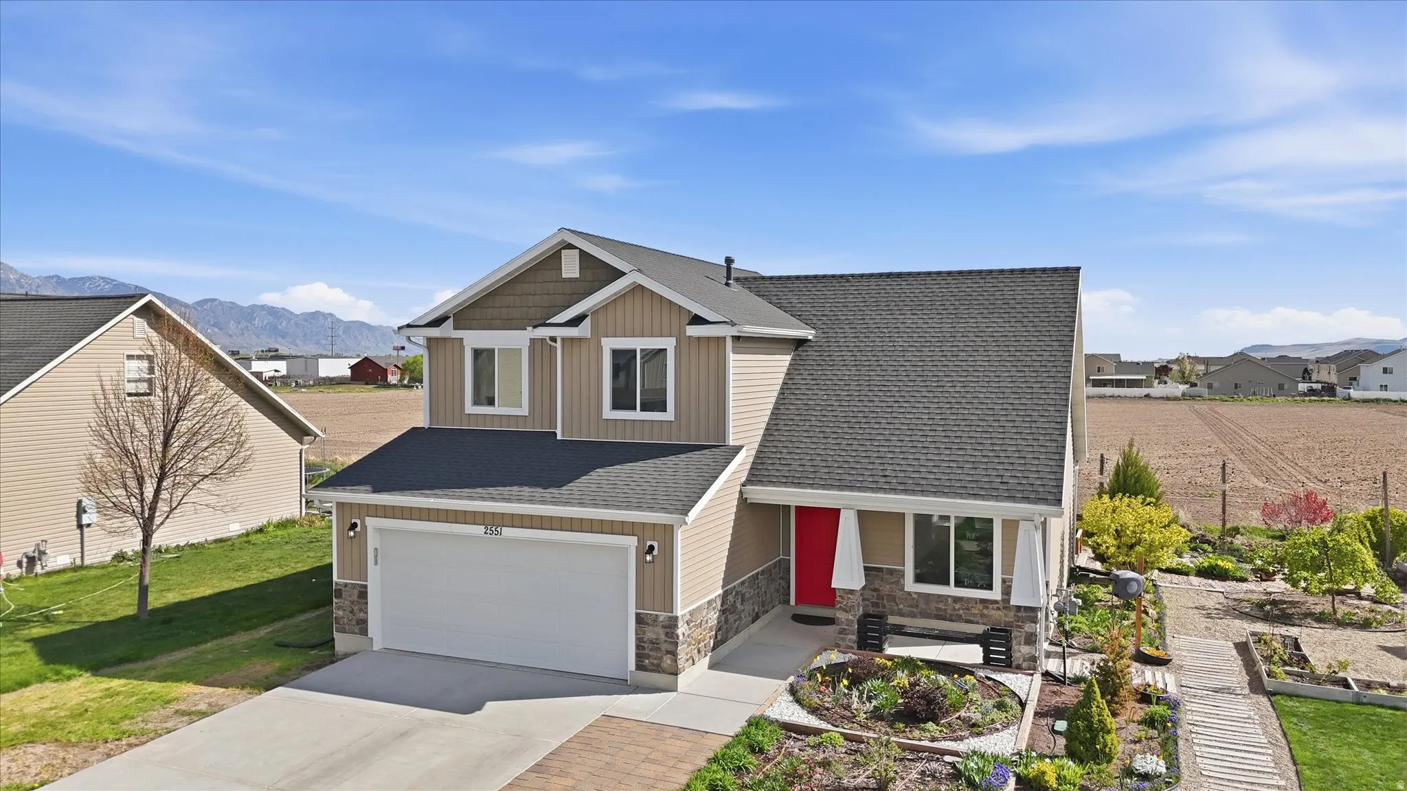 Craftsman inspired home featuring roof with shingles, driveway, stone siding, and a residential view
