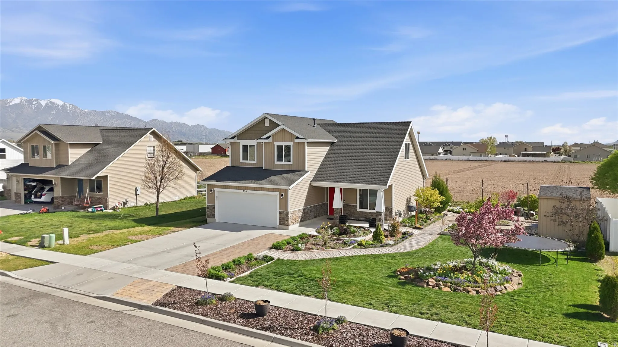 Craftsman house with a porch, a residential view, concrete driveway, stone siding, and a front yard